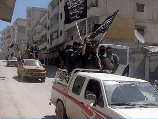 A picture posted on Twitter by Jabhat al-Nusra claims to show its fighters waving the group's flags as they tour the streets of Jisr al-Shughour on 25 April