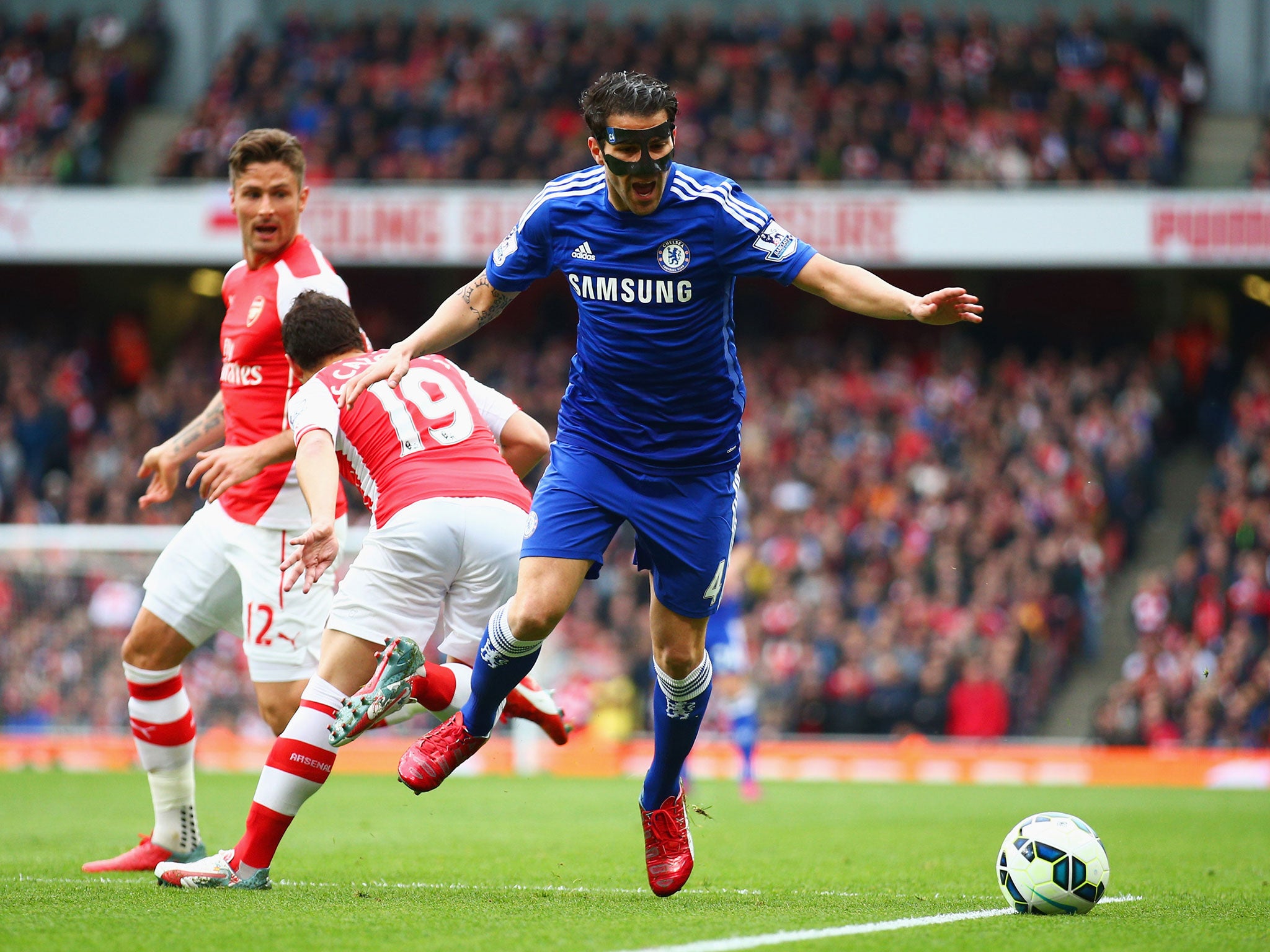 Cesc Fabreas goes down after Cazorla clash