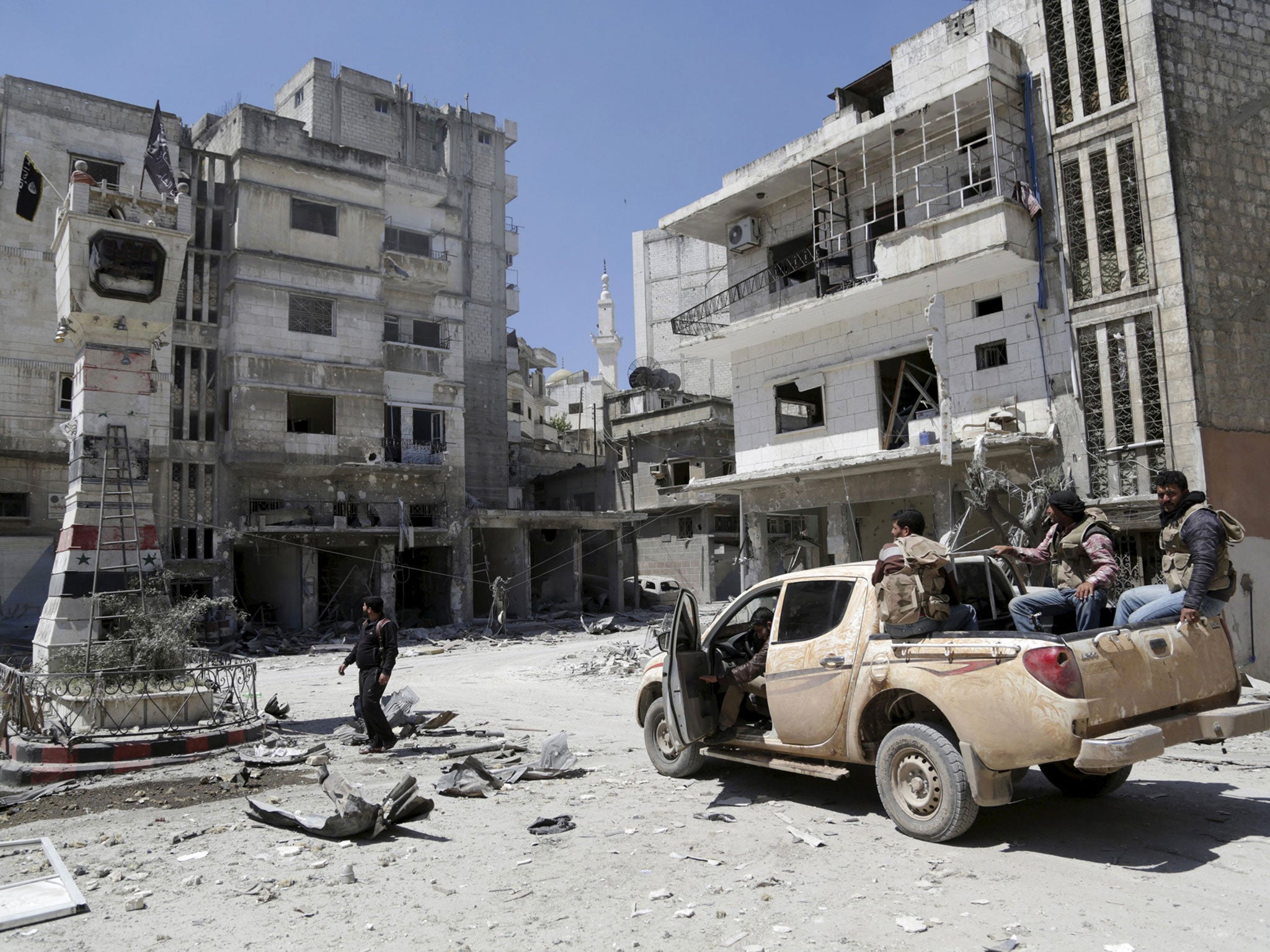 Rebel fighters inspect a site damaged by what activists said was shelling by warplanes loyal to Syria's President Bashar al-Assad in Jisr al-Shughour town