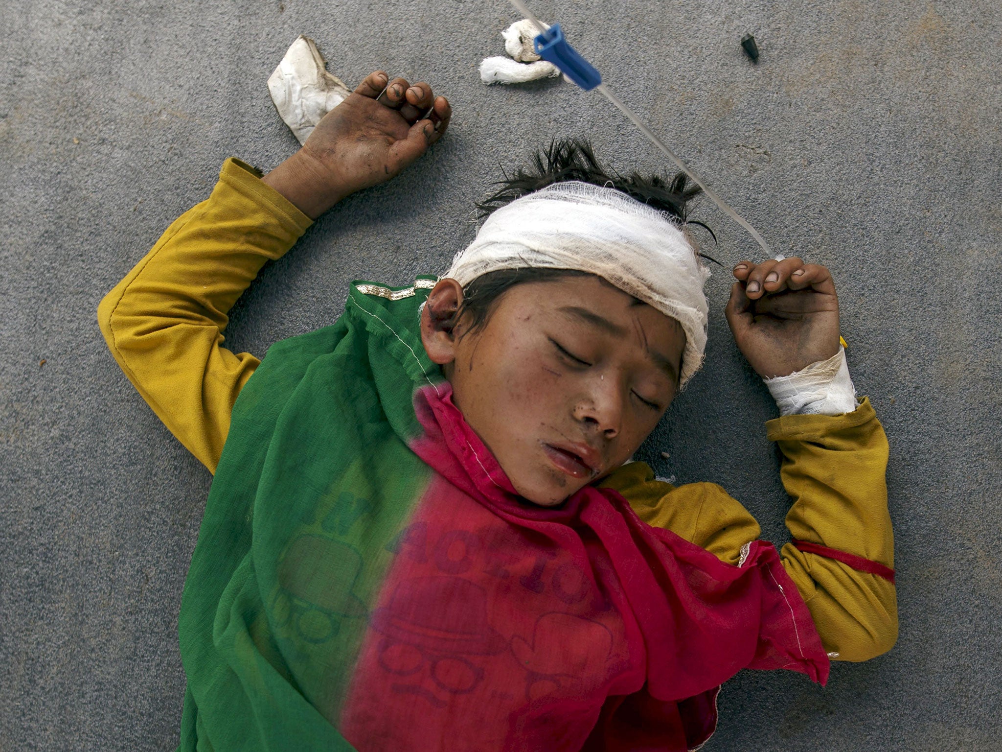 An injured boy sleeps on the ground outside the overcrowded Dhading hospital in Dhading Besi