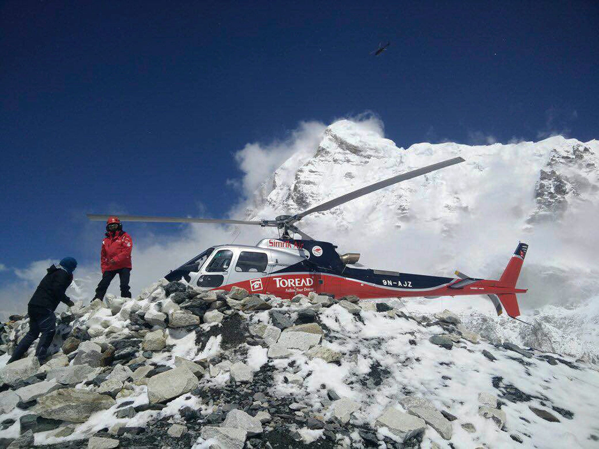 A helicopter prepares to rescue people from camp 1 and 2 at Everest Base Camp, Nepal