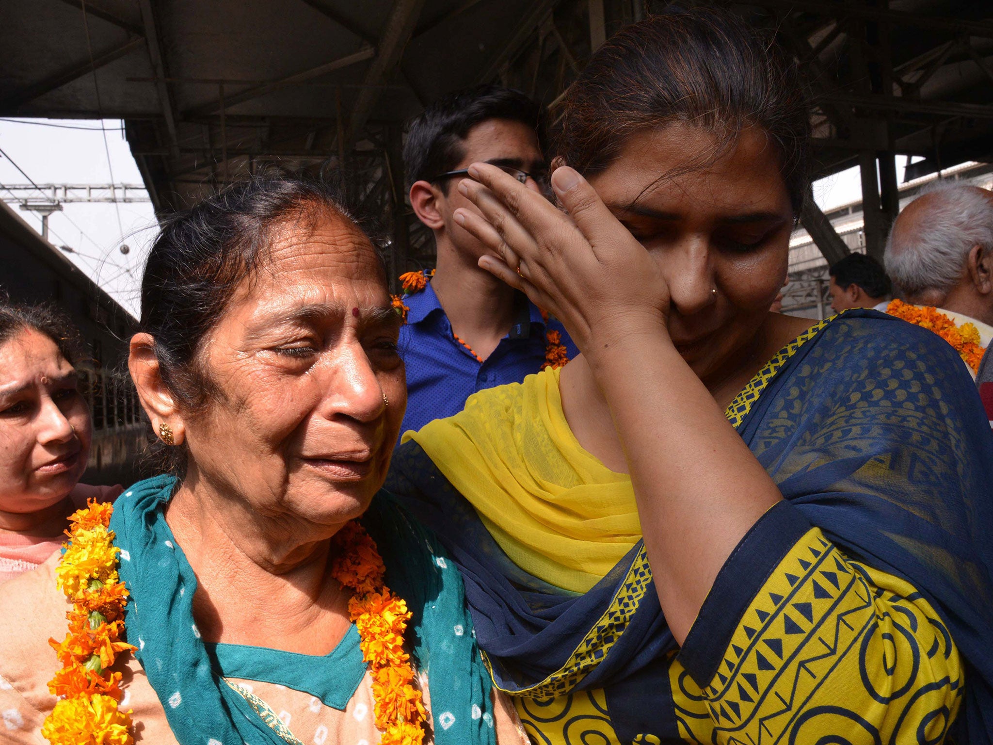 Indian resident Santosh (2L) is met by relatives after being evacuated following an earthquake in Nepal at the railway station in Amritsar