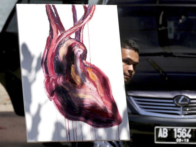 A lawyer carries a painting by Myuran Sukumaran at Wijayapura port in Cilacap