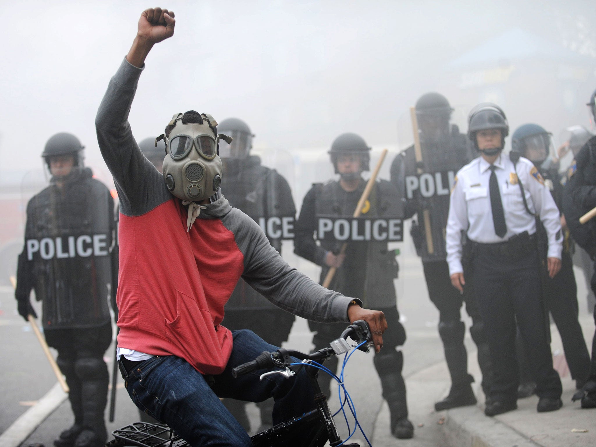 A demonstrator raises his fist as police stand in formation