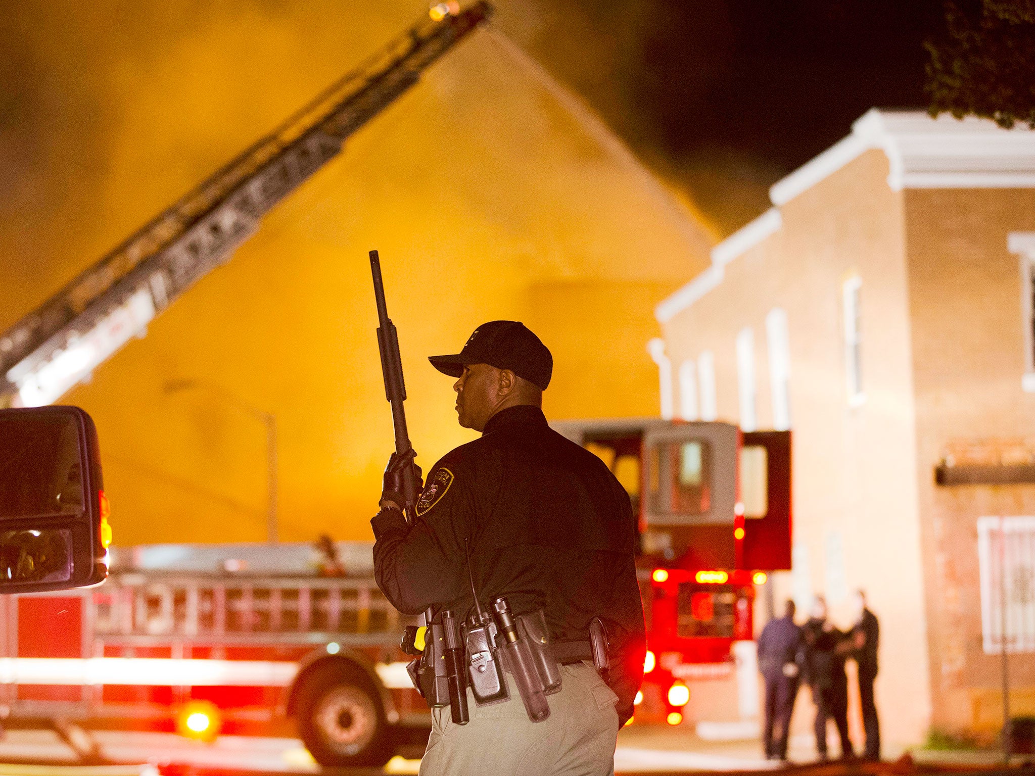 An officer stands near a blaze in Baltimore