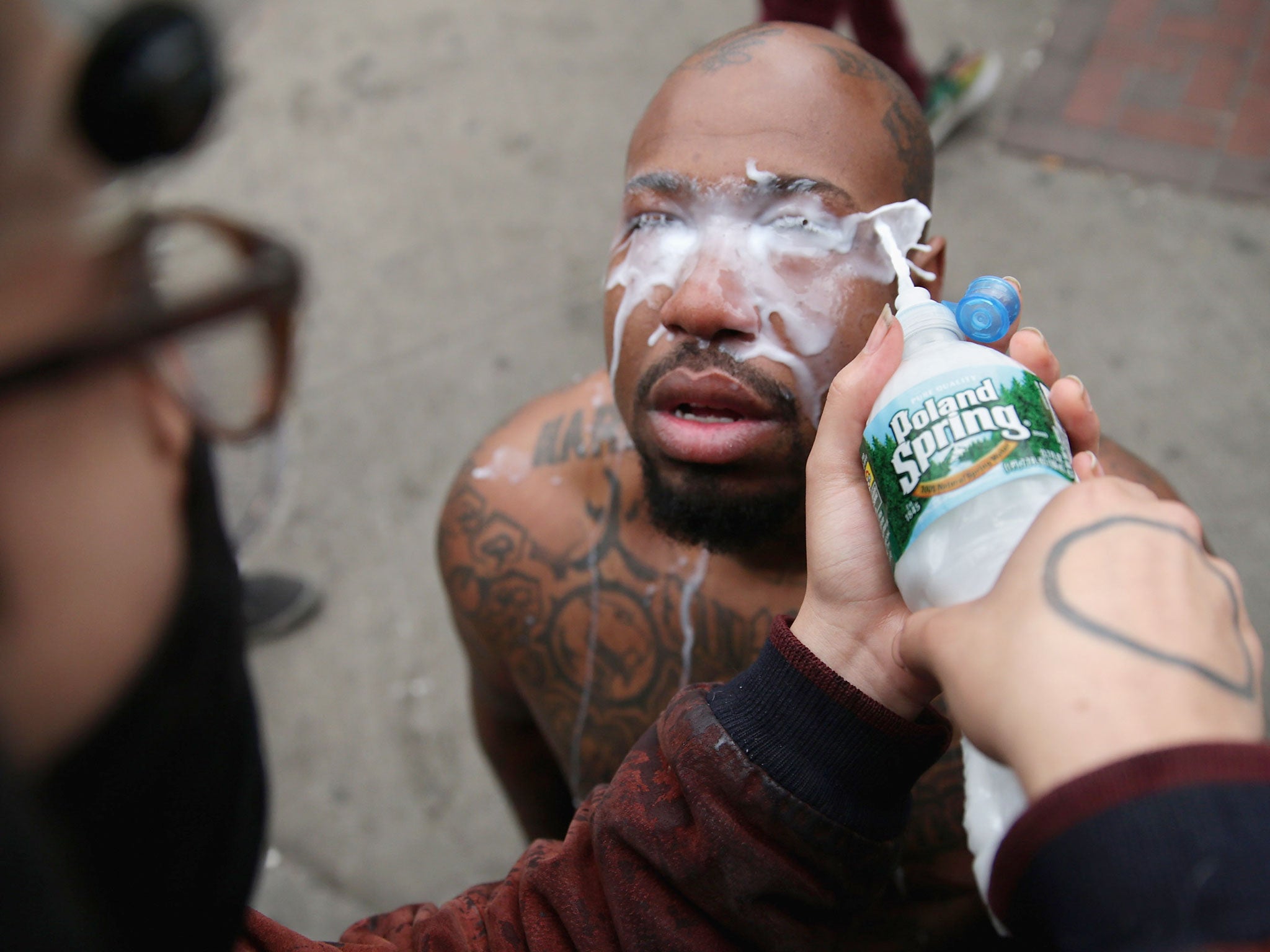 A man has his eyes cleaned after he was pepper sprayed by the Baltimore Police