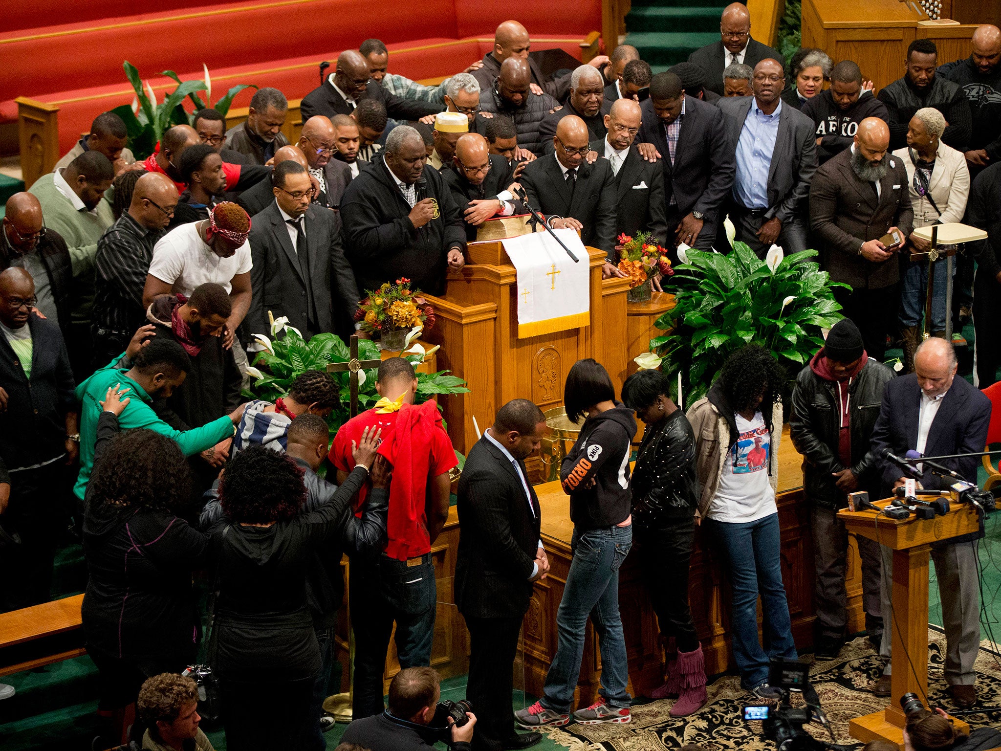 The family of Freddie Gray gather with clergy and pray during a news conference in Baltimore