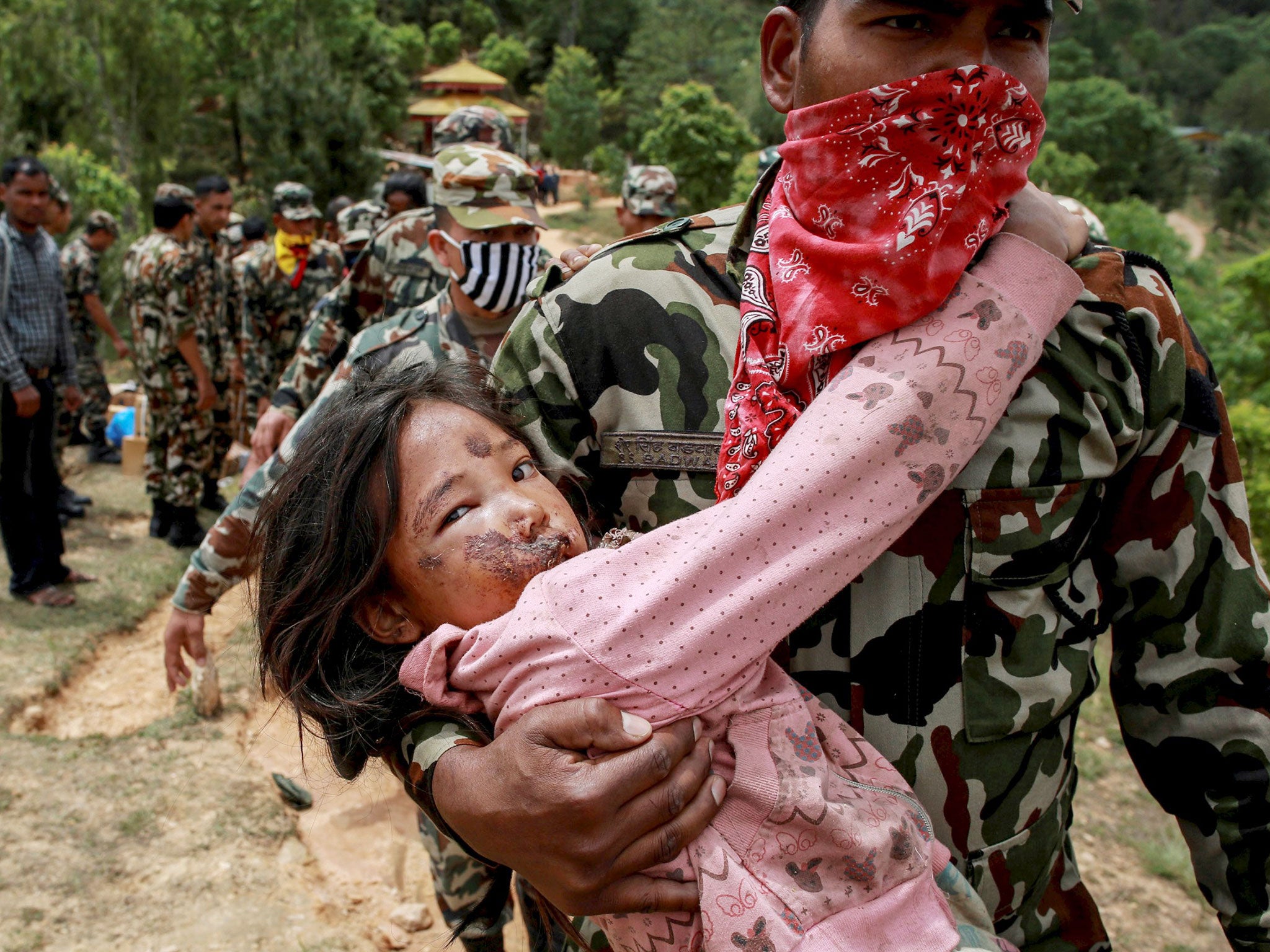 An injured girl is carried by a Nepal Army personnel to a helicopter following the earthquake in Sindhupalchowk, Nepal