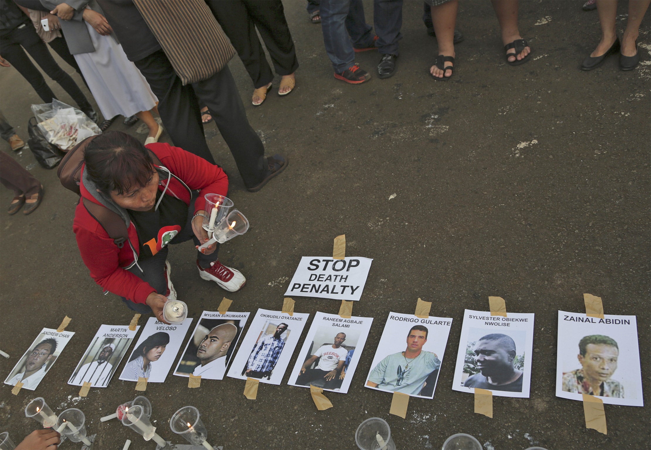 An activist holds candles near portraits of the 'Bali Nine' in Jakarta, Indonesia