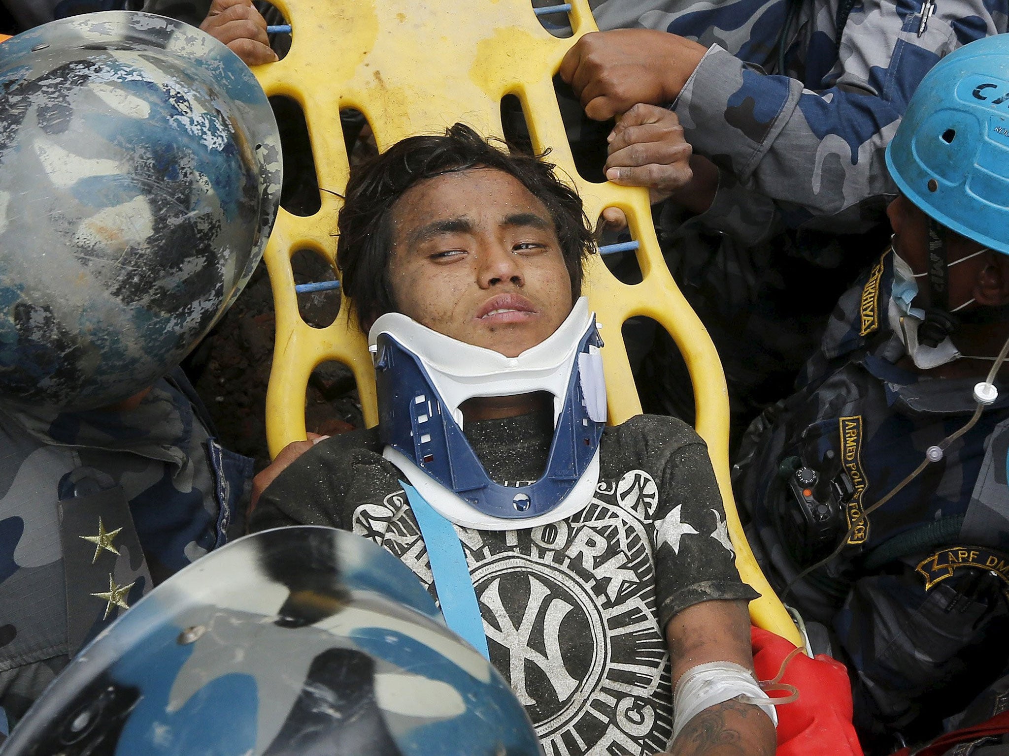 Earthquake survivor Pema Lama, 15, is rescued by the Armed Police Force from the collapsed Hilton Hotel (Reuters)