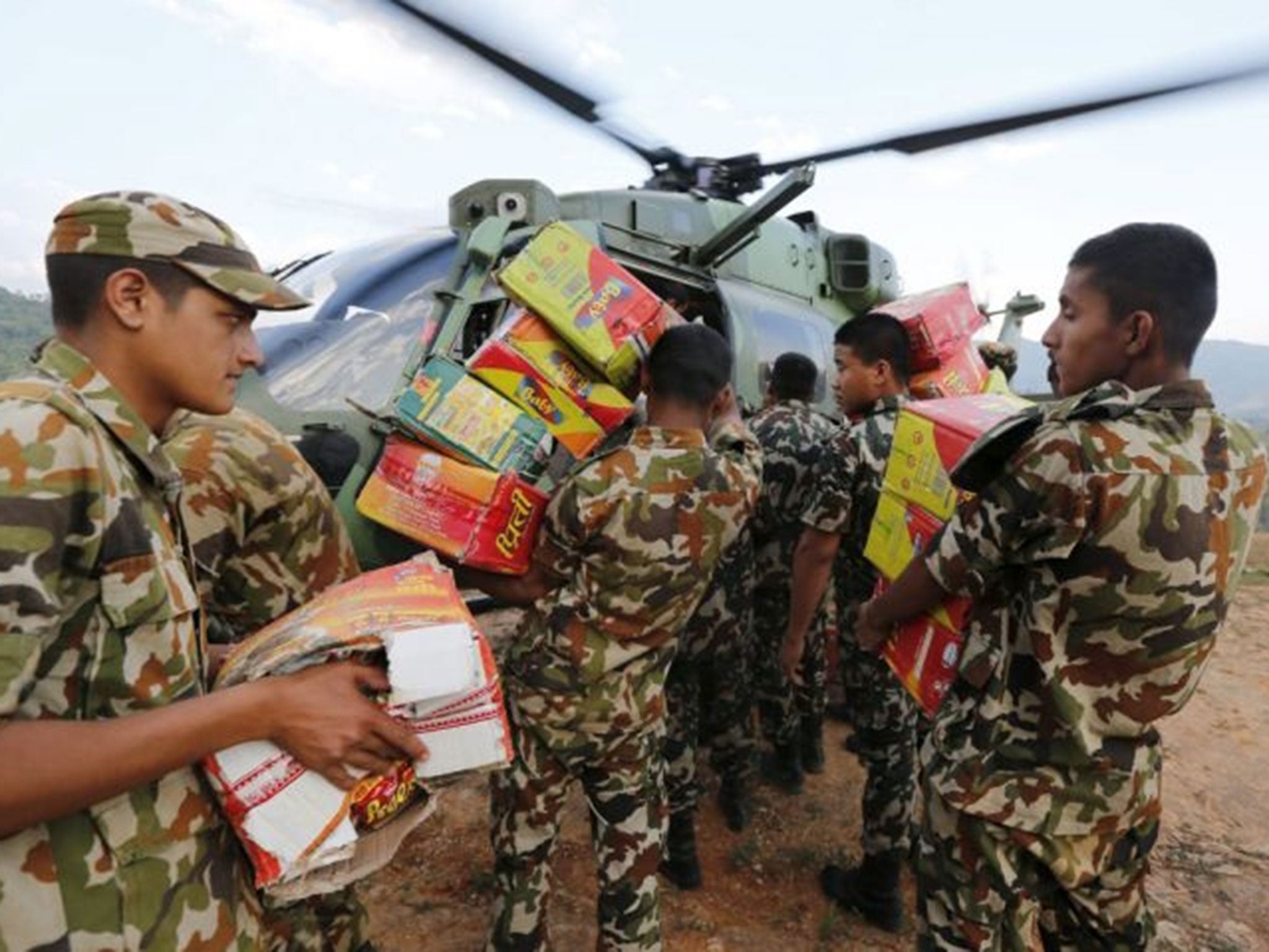 Nepalese soldiers load goods into an army helicopter in Gorkha, Nepal, to supply remote areas near the epicentre of the April earthquake