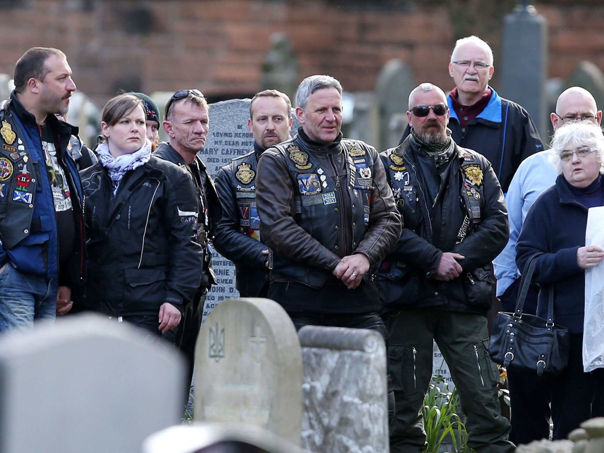 Members of the public gather round the graveside