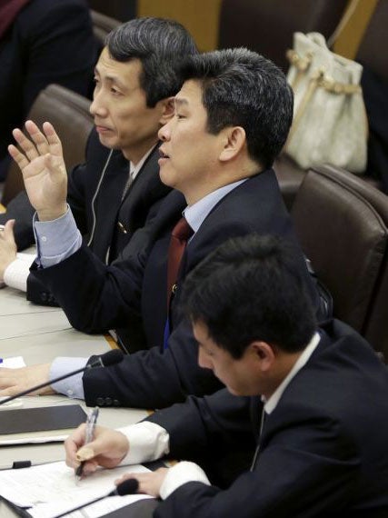 North Korean diplomats try to read a prepared statement, amid shouts from defectors on 30 April