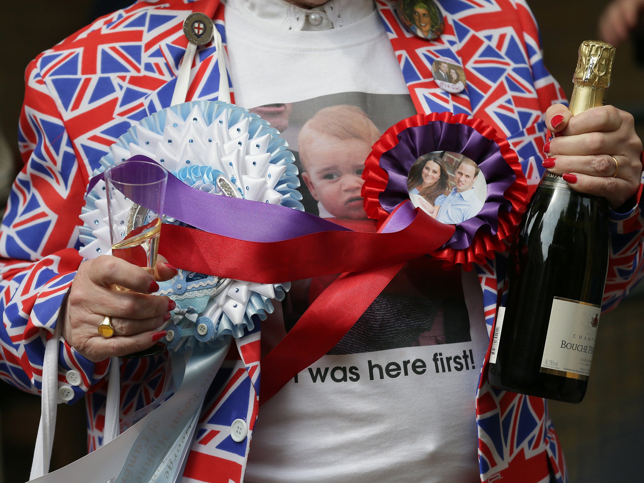 A well-wisher holds champagne to celebrate the birth of the royal baby