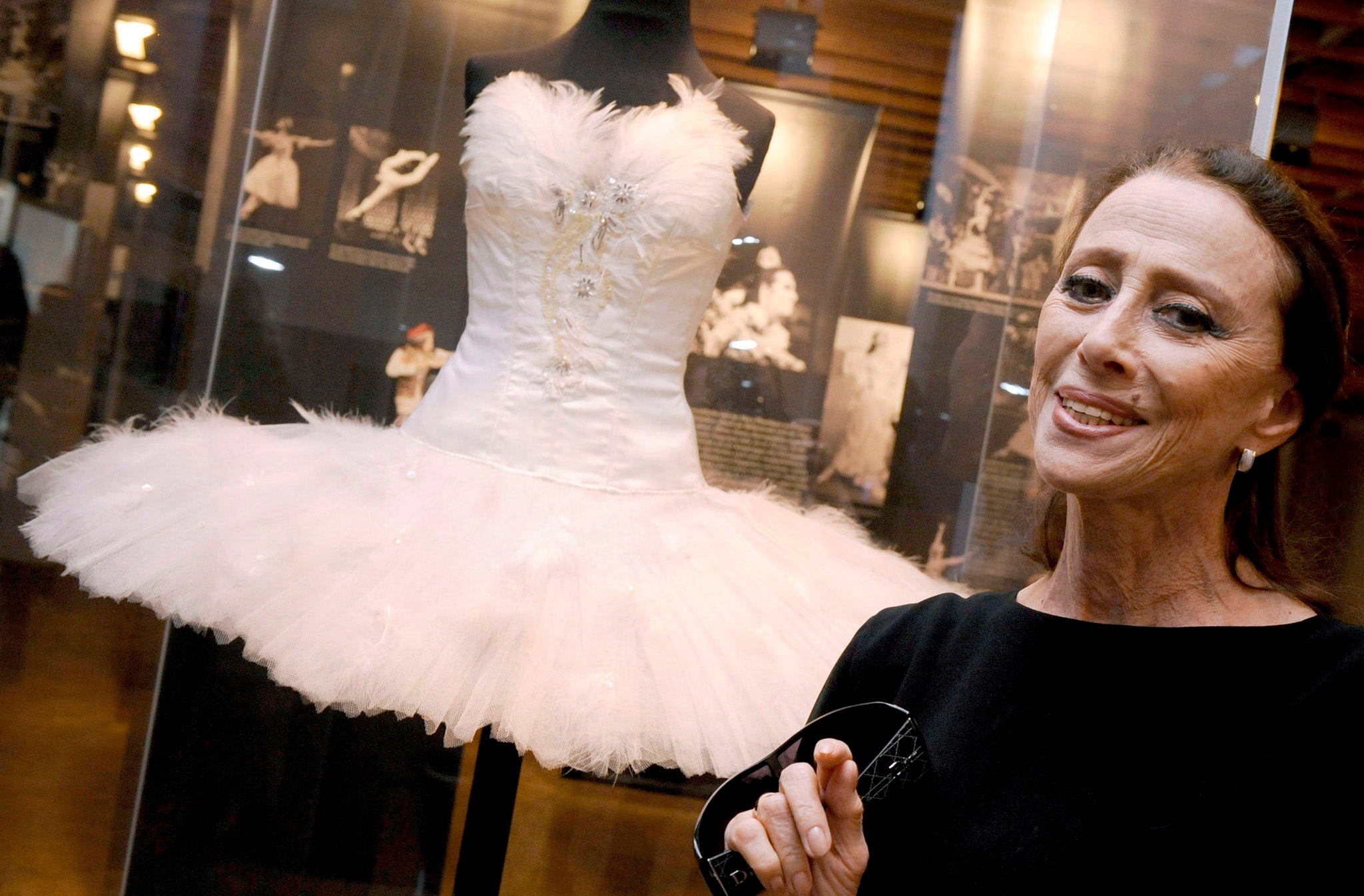 Russian ballet legend Maya Plisetskaya posing in front of the ballet costume she once wore in 'Swan Lake'