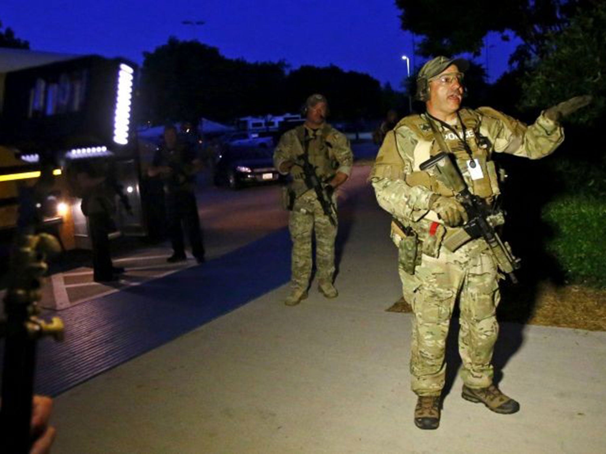 A police officer directs the evacuation of attendees of the Muhammad Art Exhibit and Contest, after a shooting outside the Curtis Culwell Center where the event was held in Garland, Texas on 3 May.