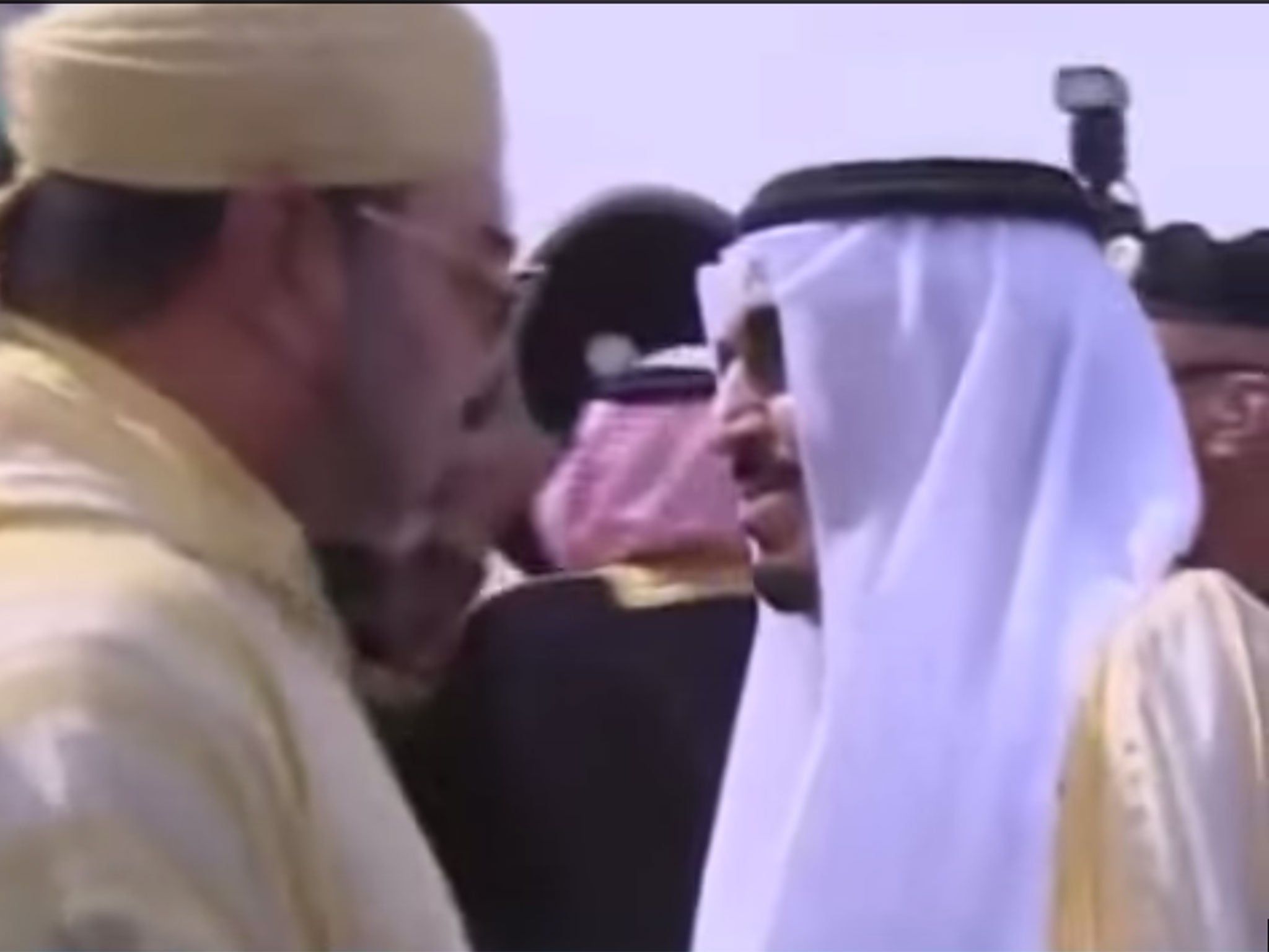 Saudi Arabia's King Salman greets Morocco's King Mohammed. But it's what is going on behind them that has attracted social media attention