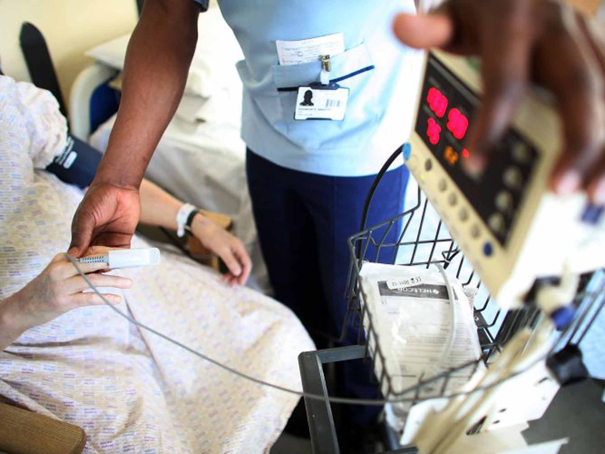 A nurse tends to a recovering patient on a general ward at The Queen Elizabeth Hospital in Birmingham