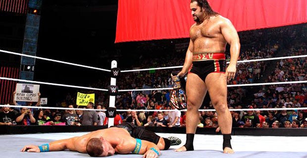 Rusev looks down at John Cena after attacking him and Neville