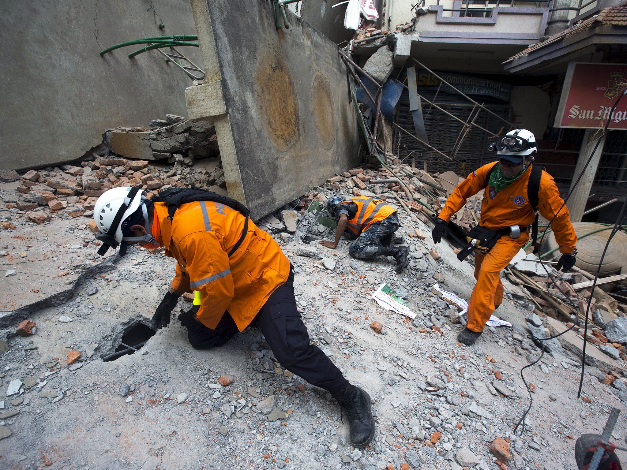 Nepalese military personnel and International rescue check on a collapsed building after an earthquake in the centre of Kathmandu on 12 May