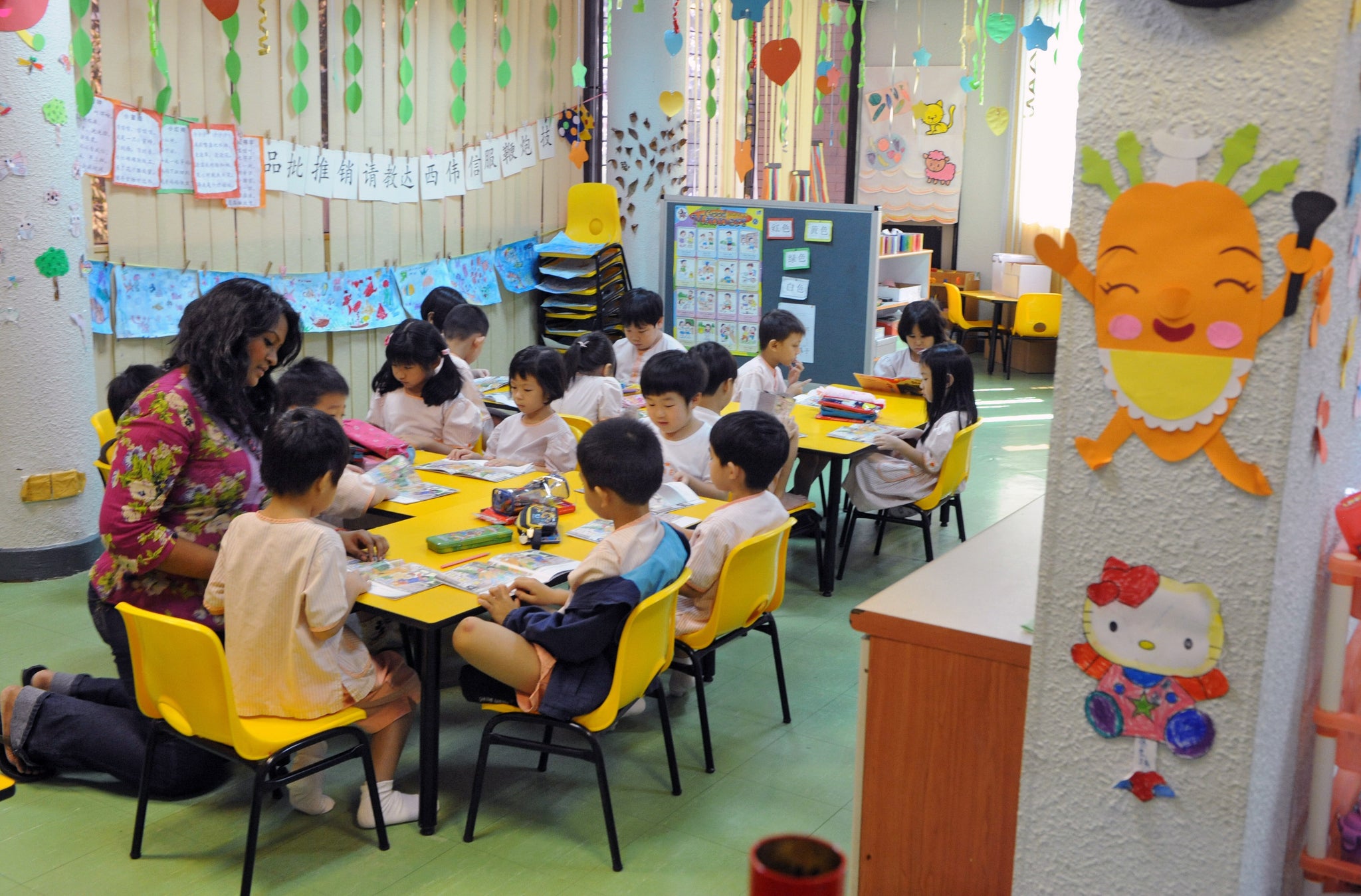 Getty: A teacher guides children to read a story book during a lesson in Singapore