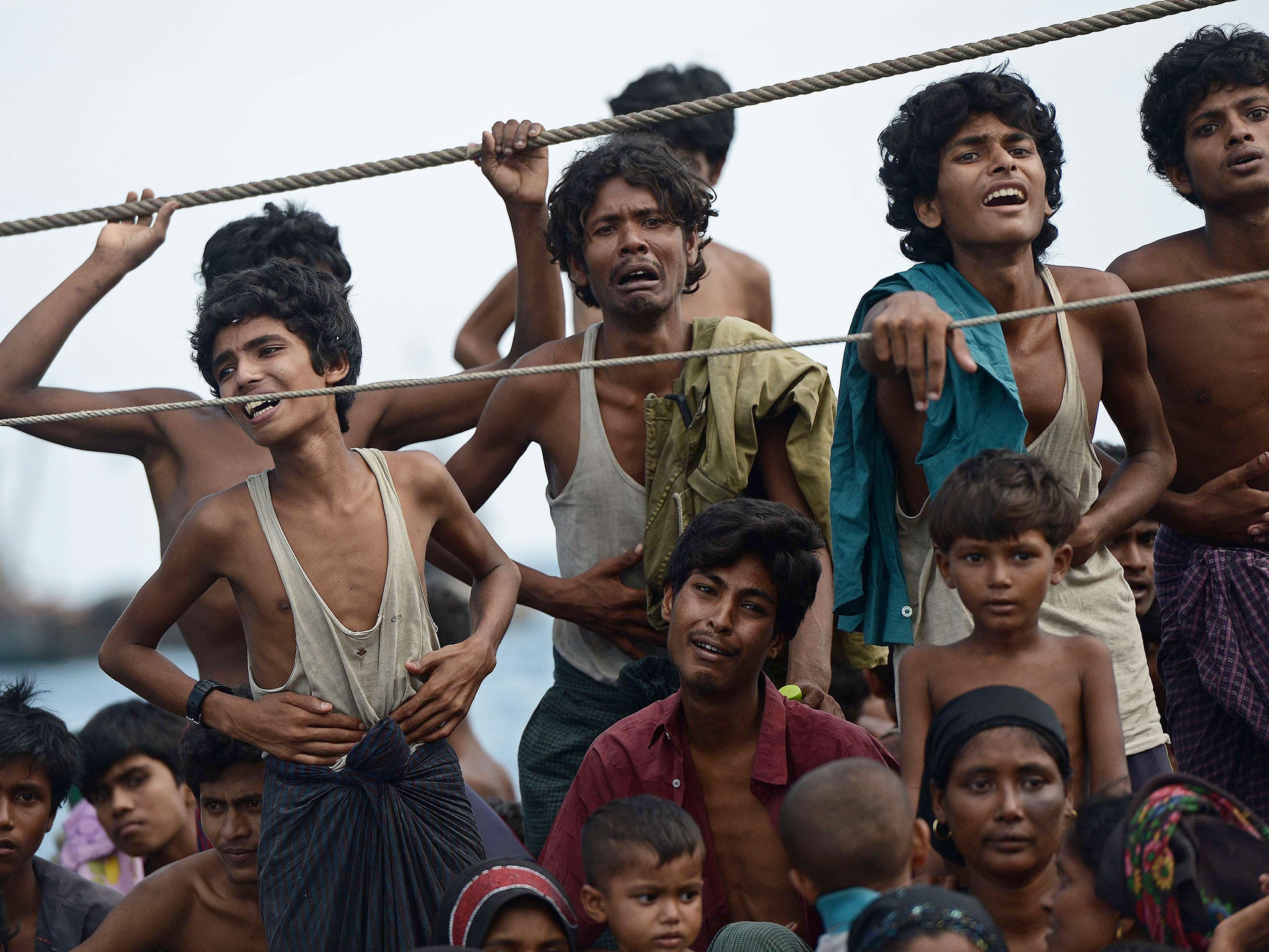 Rohingya migrants stand and sit on a boat drifting in Thai waters