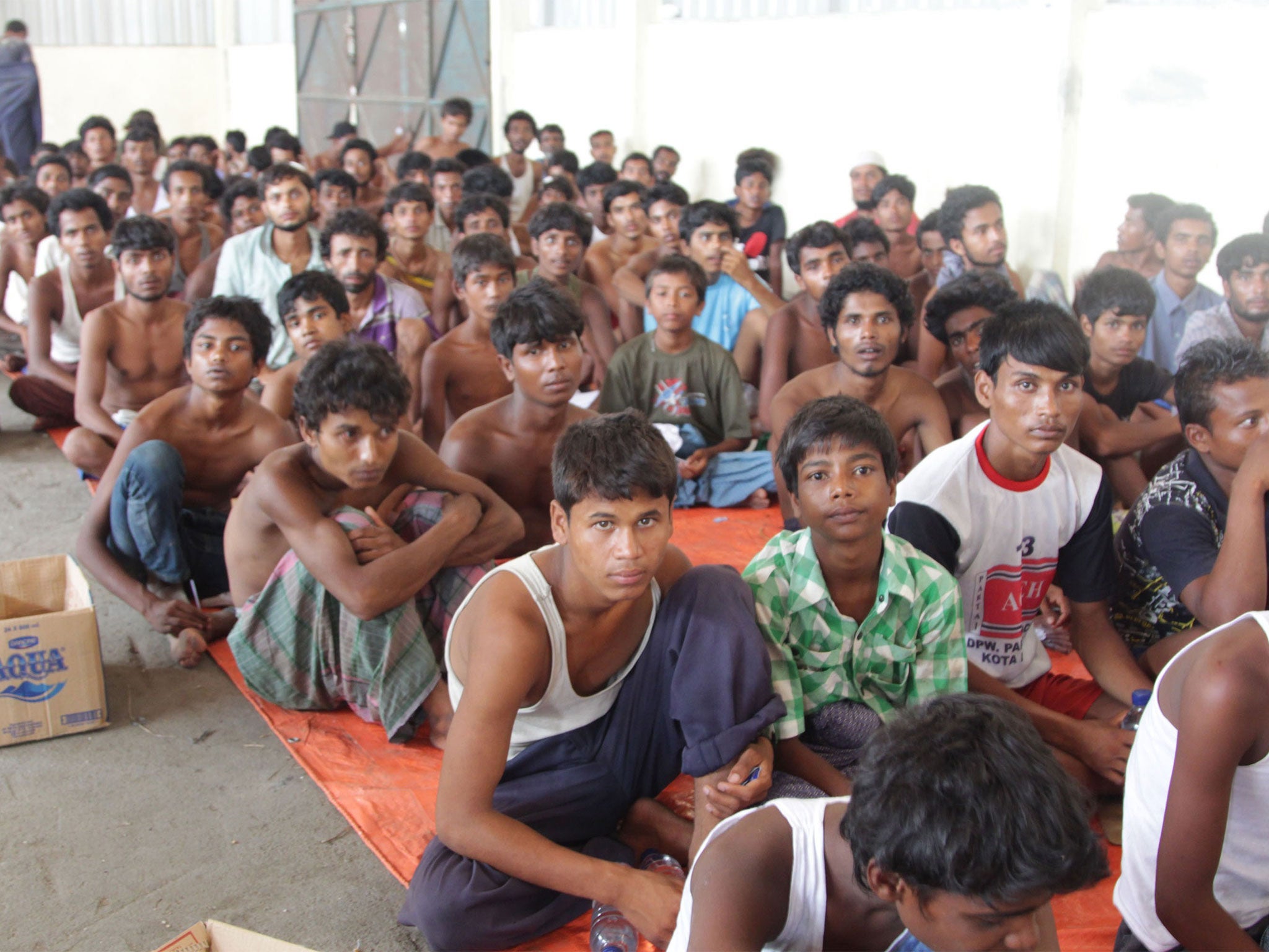 A group of rescued migrants mostly Rohingya from Myanmar and Bangladesh gather on arrival at the new confinement area in the fishing town of Kuala Langsa