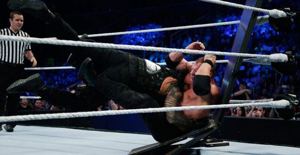 Roman Reigns spears Kane through a table