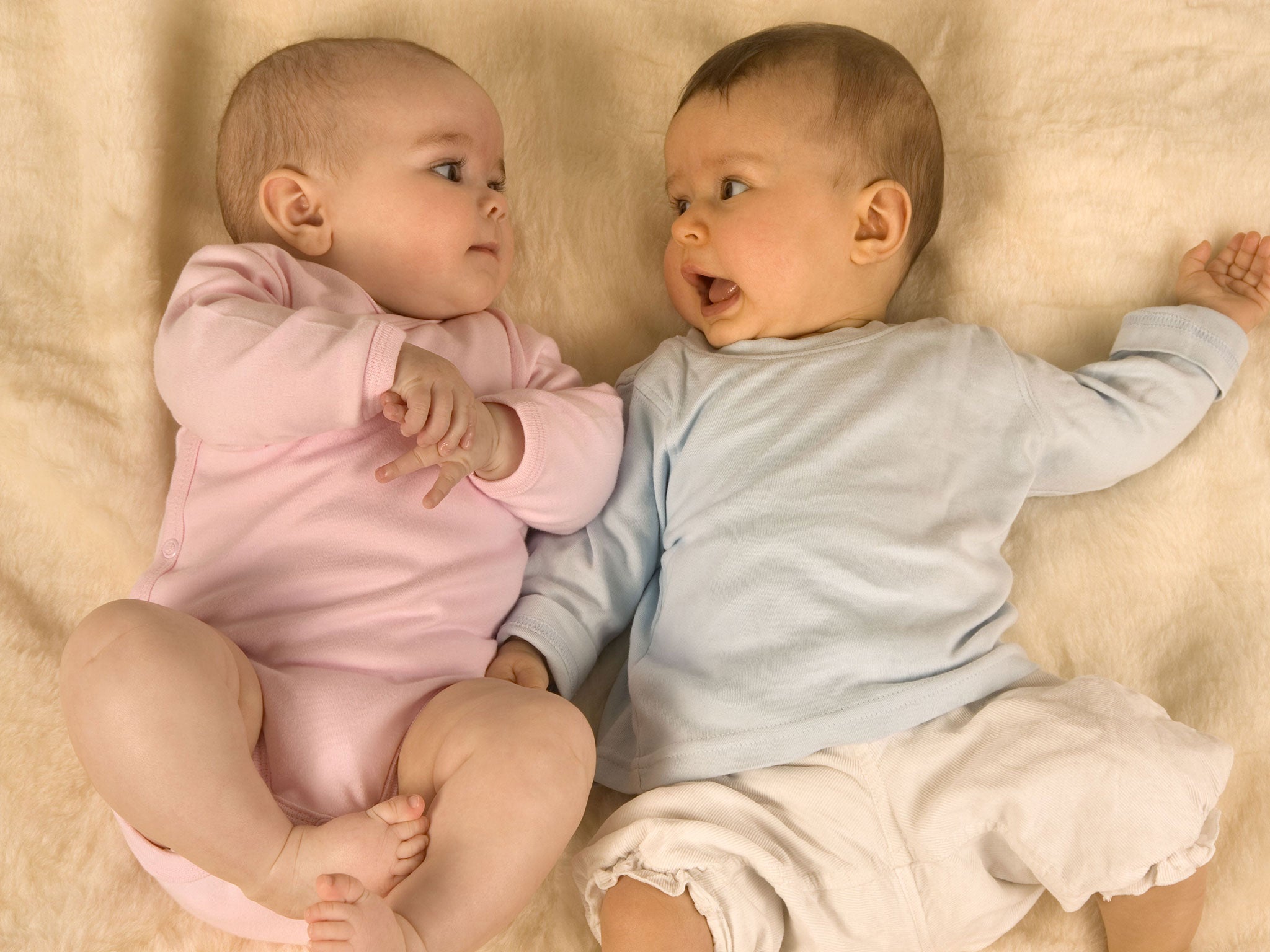 Two babies lying down together, model released