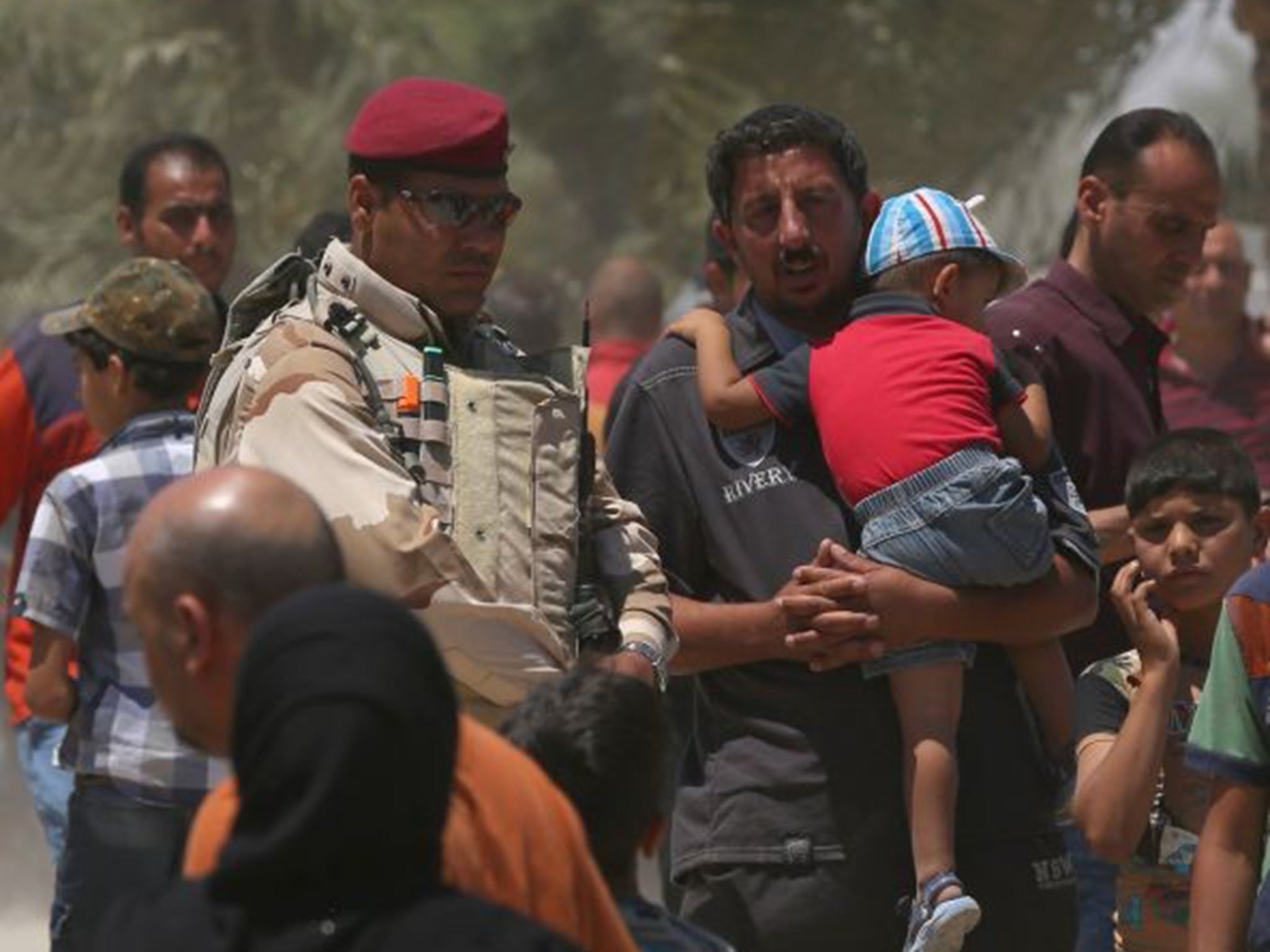 Iraqis fleeing from their hometown of Ramadi walk on a street near the Bzebiz bridge, 65 kilometers (40 miles) west of Baghdad