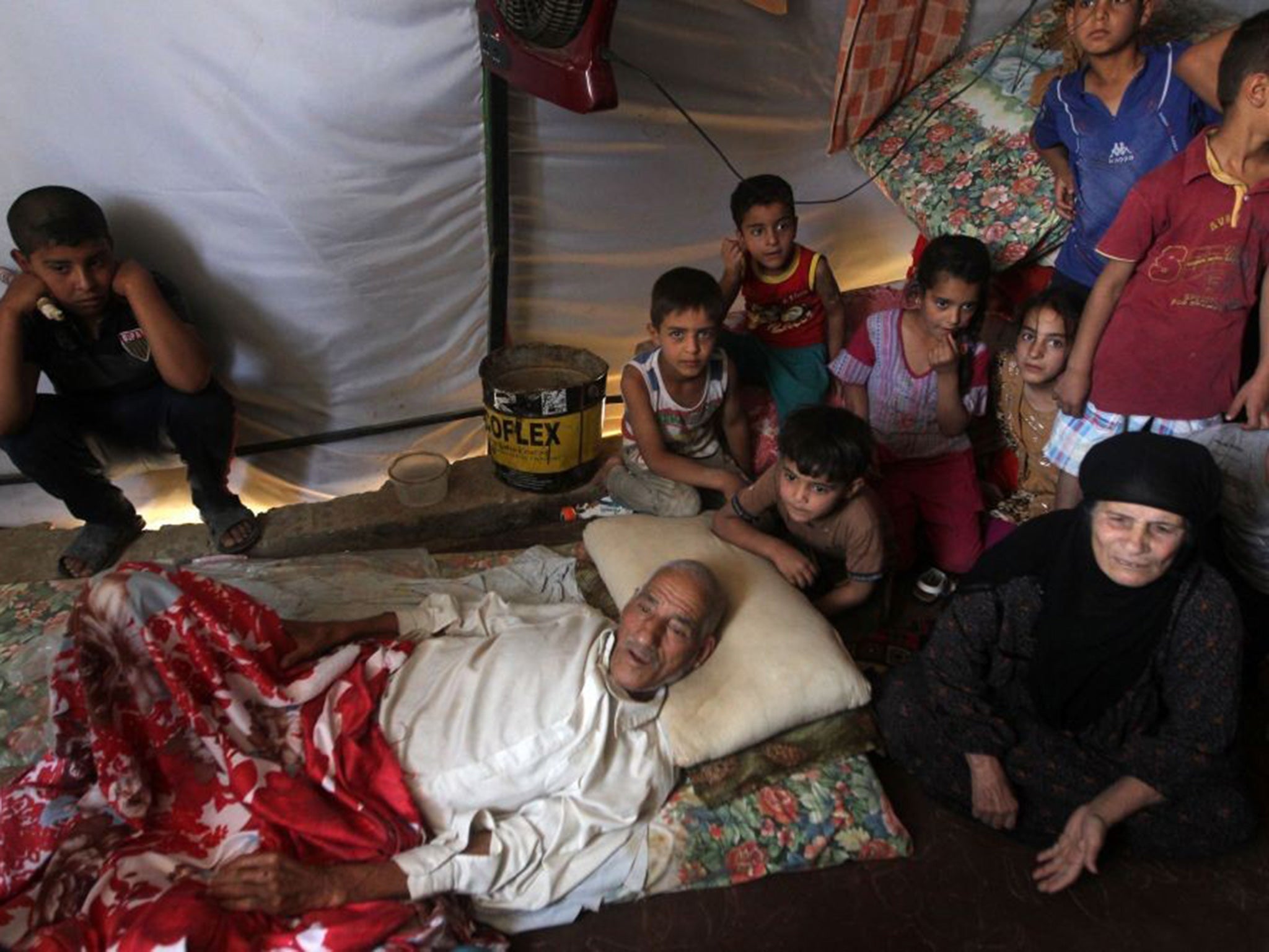 An Iraqi family, who fled the city of Ramadi after it was seized by Islamic State (IS) group militants, gathers inside a tent at a camp housing displaced families.