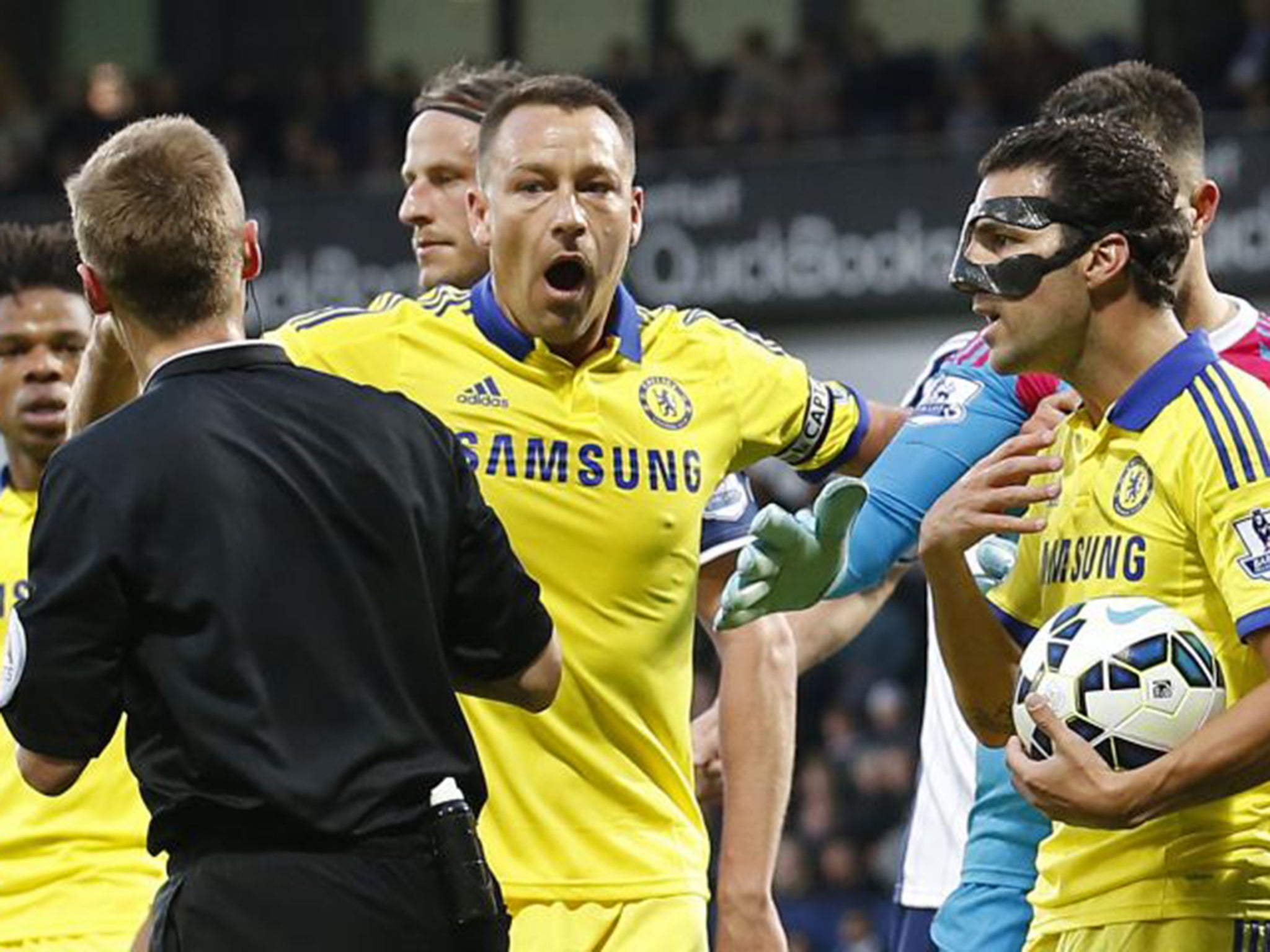 Cesc Fabregas, right, and John Terry argue with referee Mike Jones as the Spaniard gets a red card for kicking the ball at the head of Chris Brunt