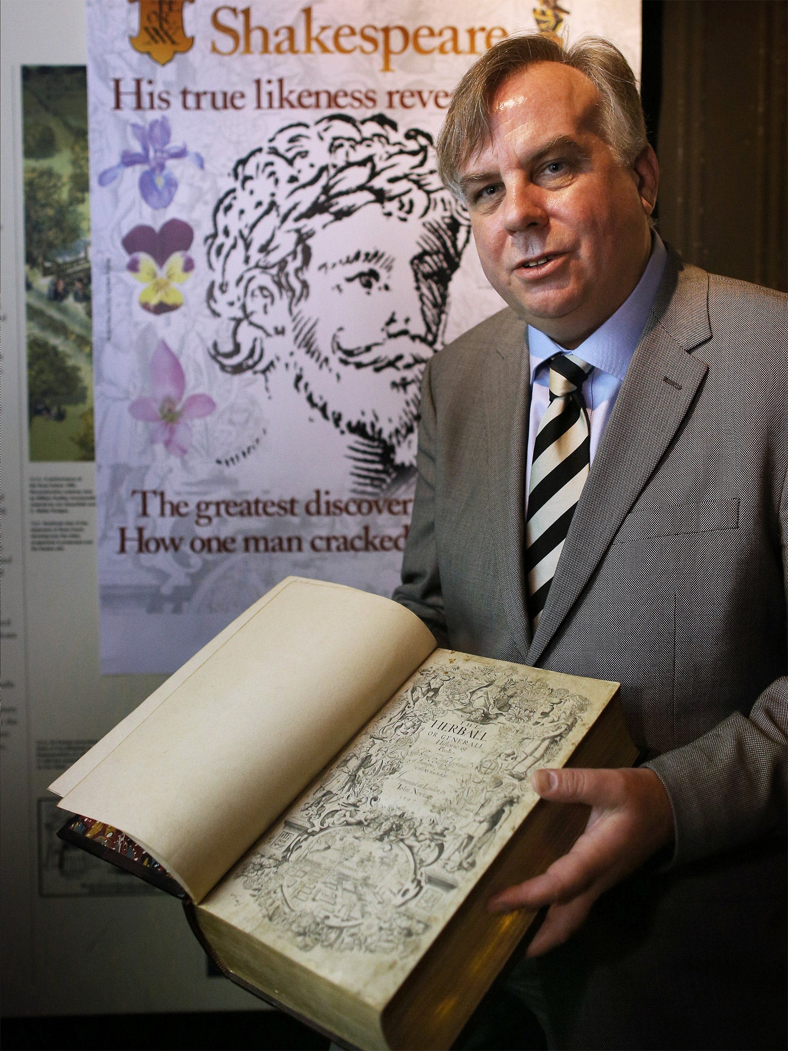 Historian Mark Griffiths holds a copy of The Herball book that contains the alleged portrait of William Shakespeare (Getty)