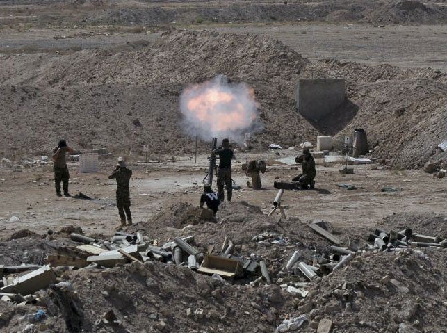 Members of the Iraqi army and Shia fighters launch a mortar toward Islamic State militants on the outskirts of Fallujah on 19 May