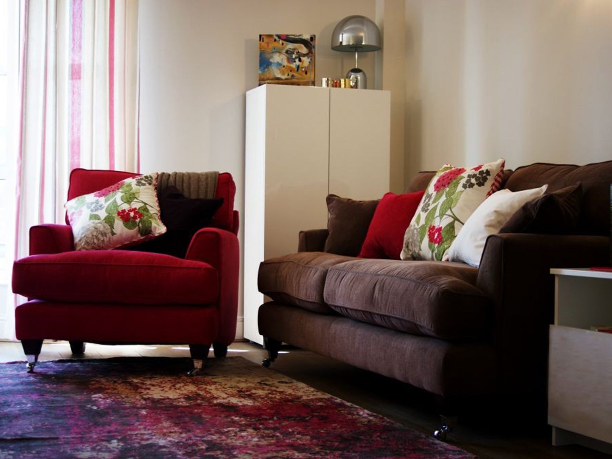 Sofa Workshop’s Florence armchair in vogue hot pink with the mole sofa from the range; Toiles de Mayenne curtains from Prêt à Vivre; Plantation Rug Company’s Impressions rug on Moduleo Verdon Oak flooring; and Tom Dixon Bell lamp and candles from StreetHub.