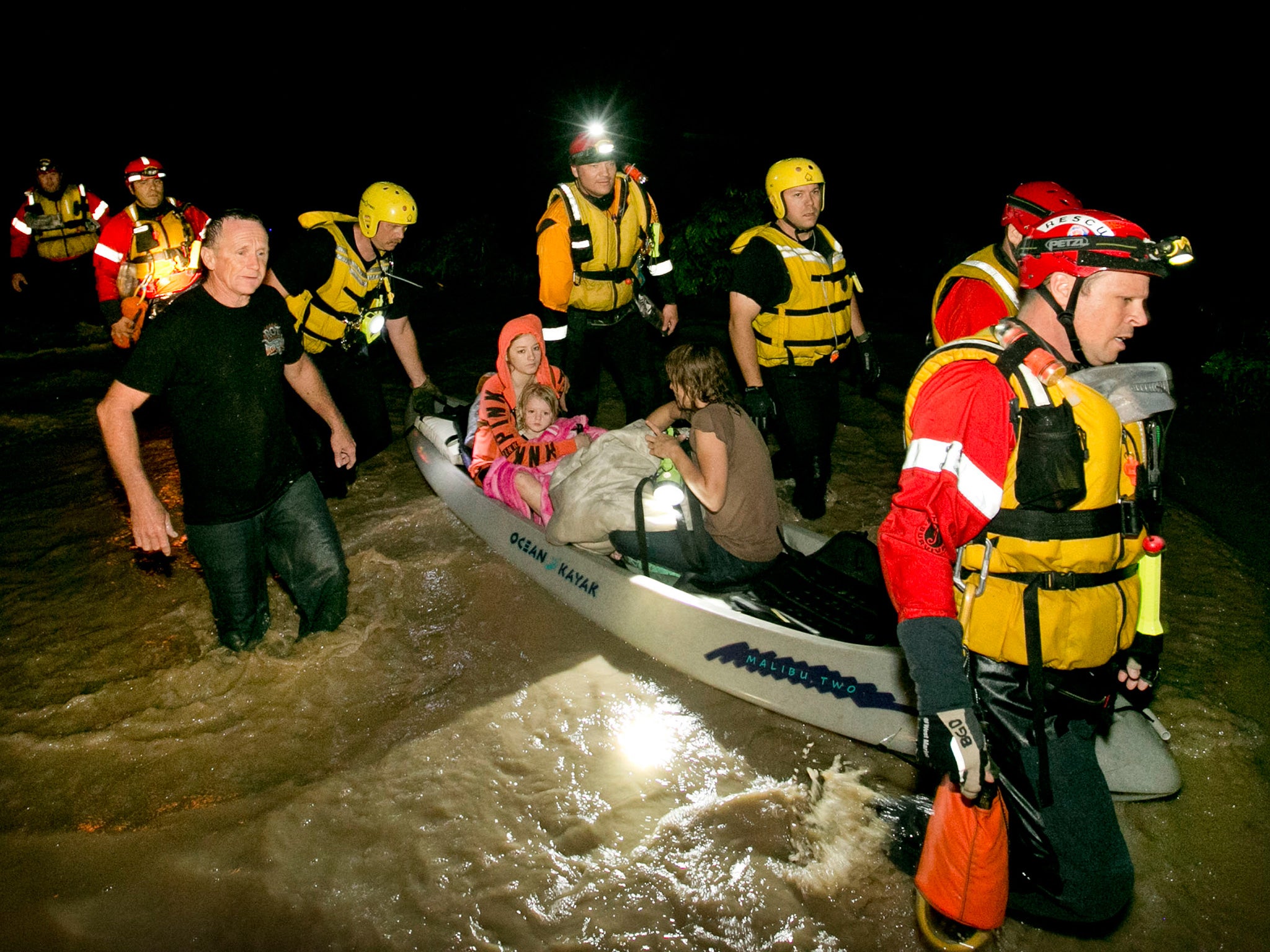 Mark Norris, Retha Norris, Ally Smith and Christina Norris, are rescued by firefighters after they clung in a tree at their home in Texas