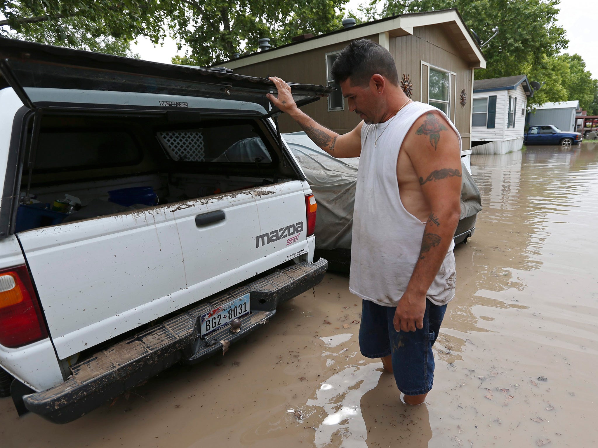 Keith Varela inspects the damage to his wife's truck in San Marcos