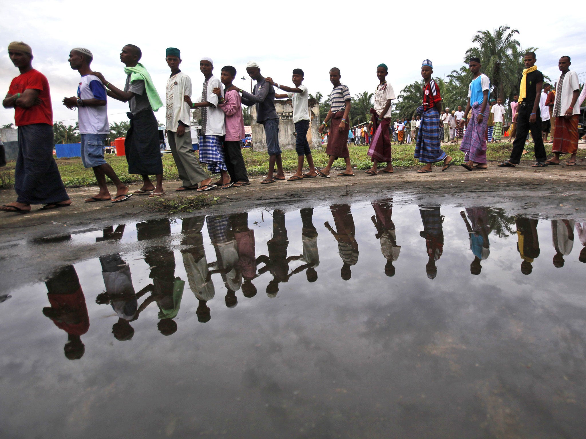 Rohingya migrants queue for food at a temporary shelter in Bayeun, Aceh province, in Indonesia