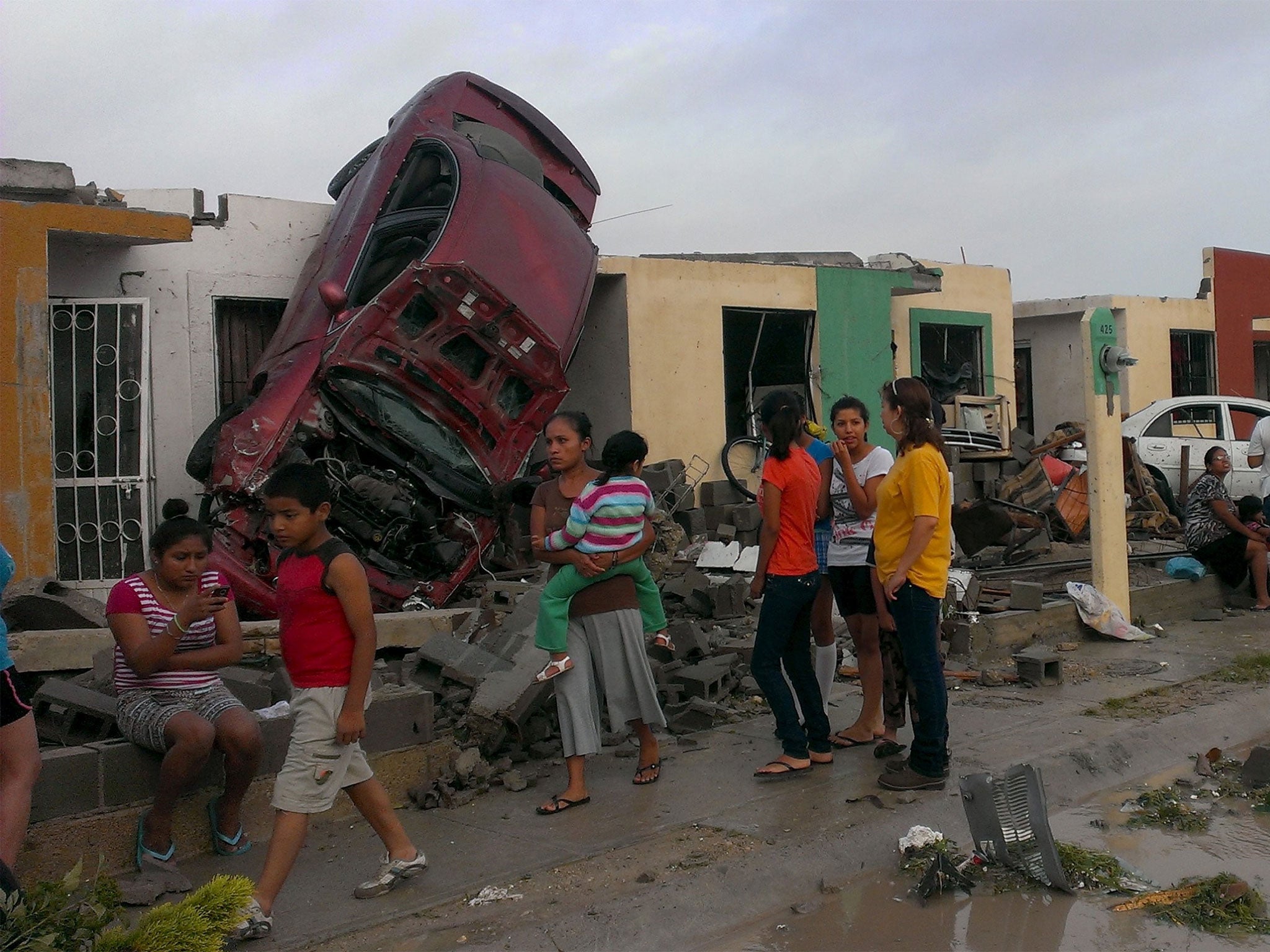 Residents of Ciudad Acuna stand by their homes after the tornado swept through the boder city