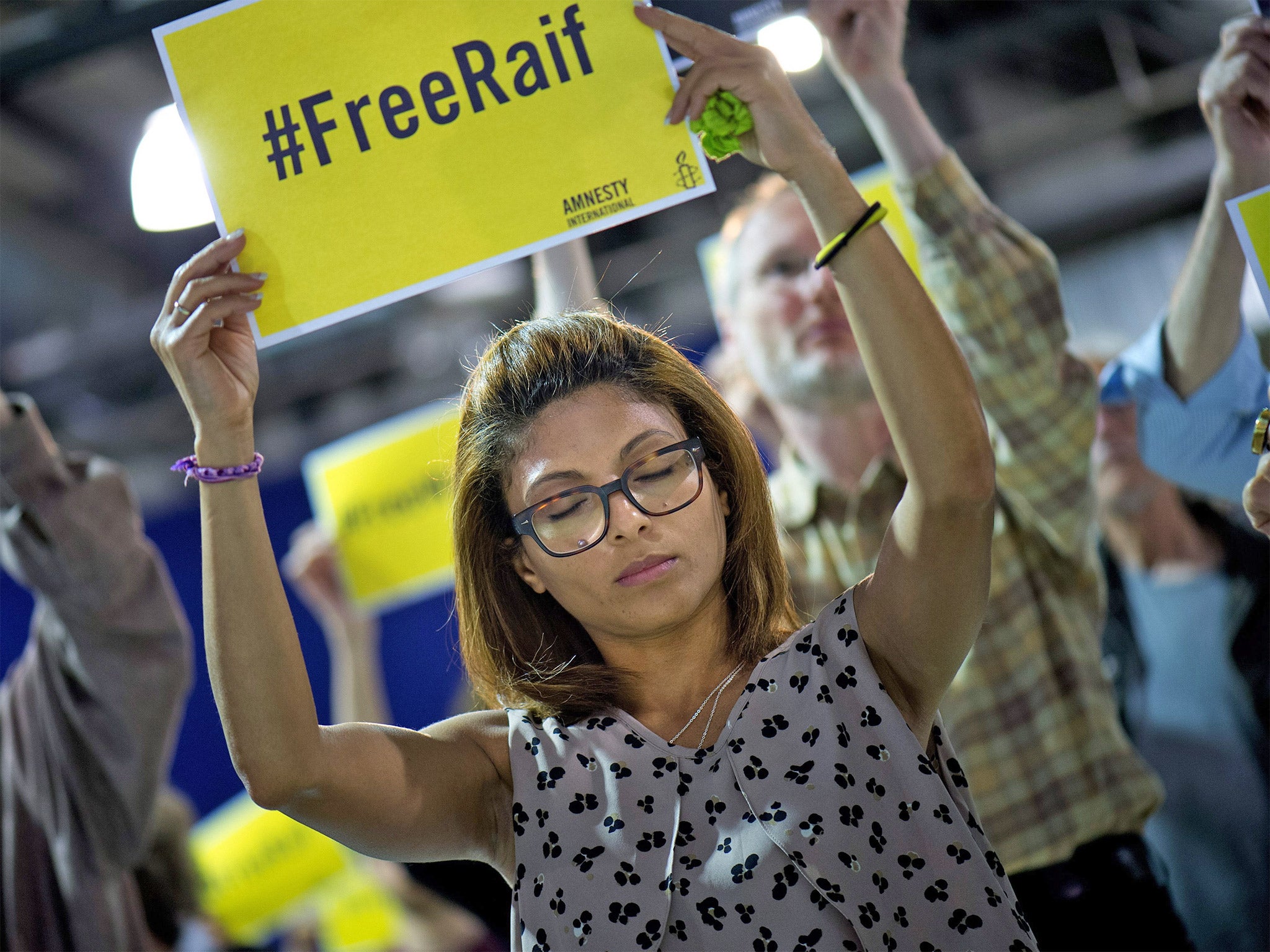 Ensaf Haidar holds a placard after her speech as a guest at the annual meeting of the German section of Amnesty International in Dresden last week