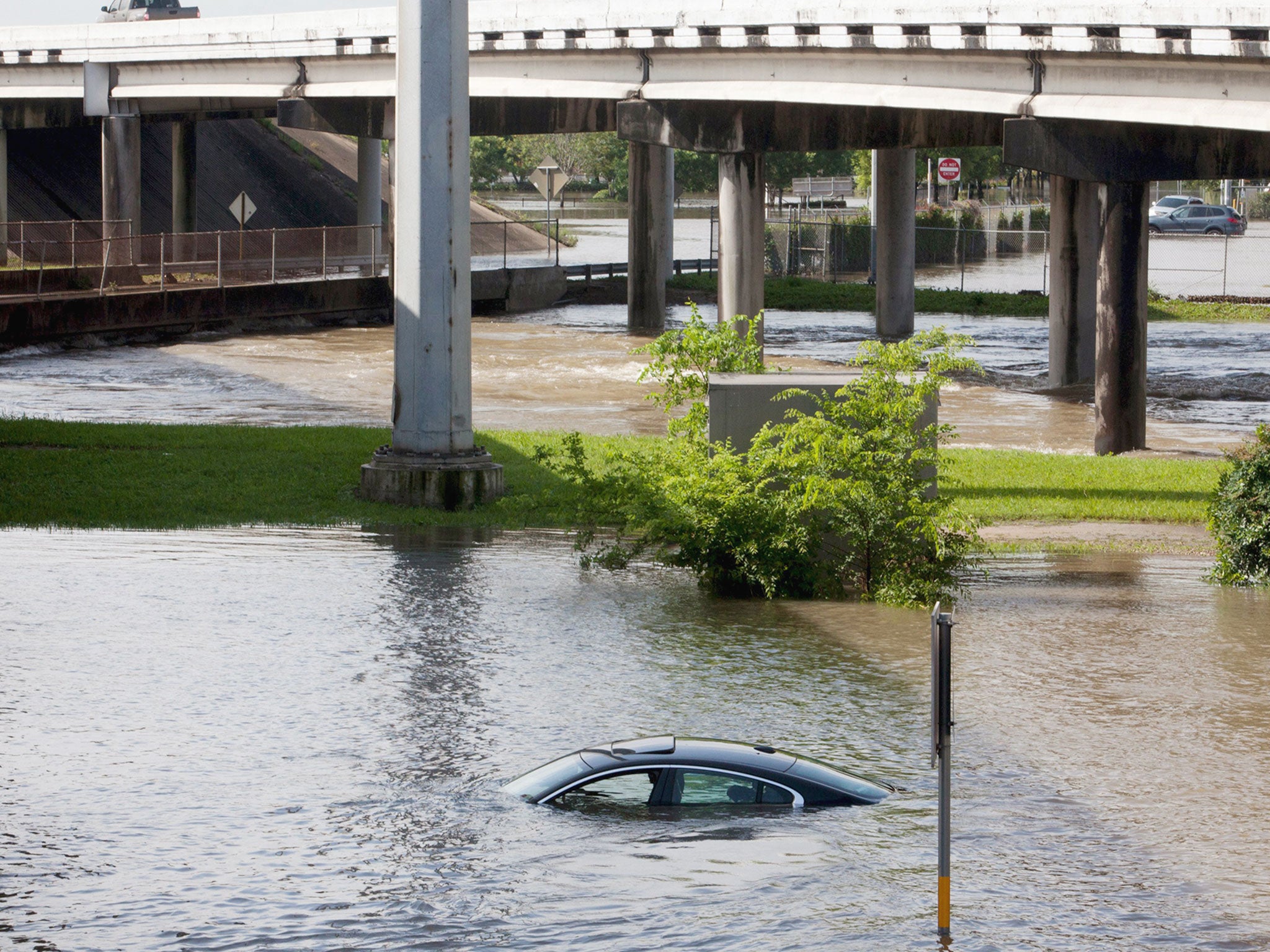 Flood waters cover a car in South Houston