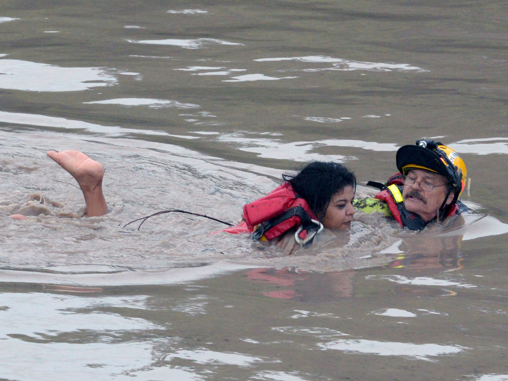 San Marcos Firefighter Jay Horton rescues a woman from in flood waters in San Marcos