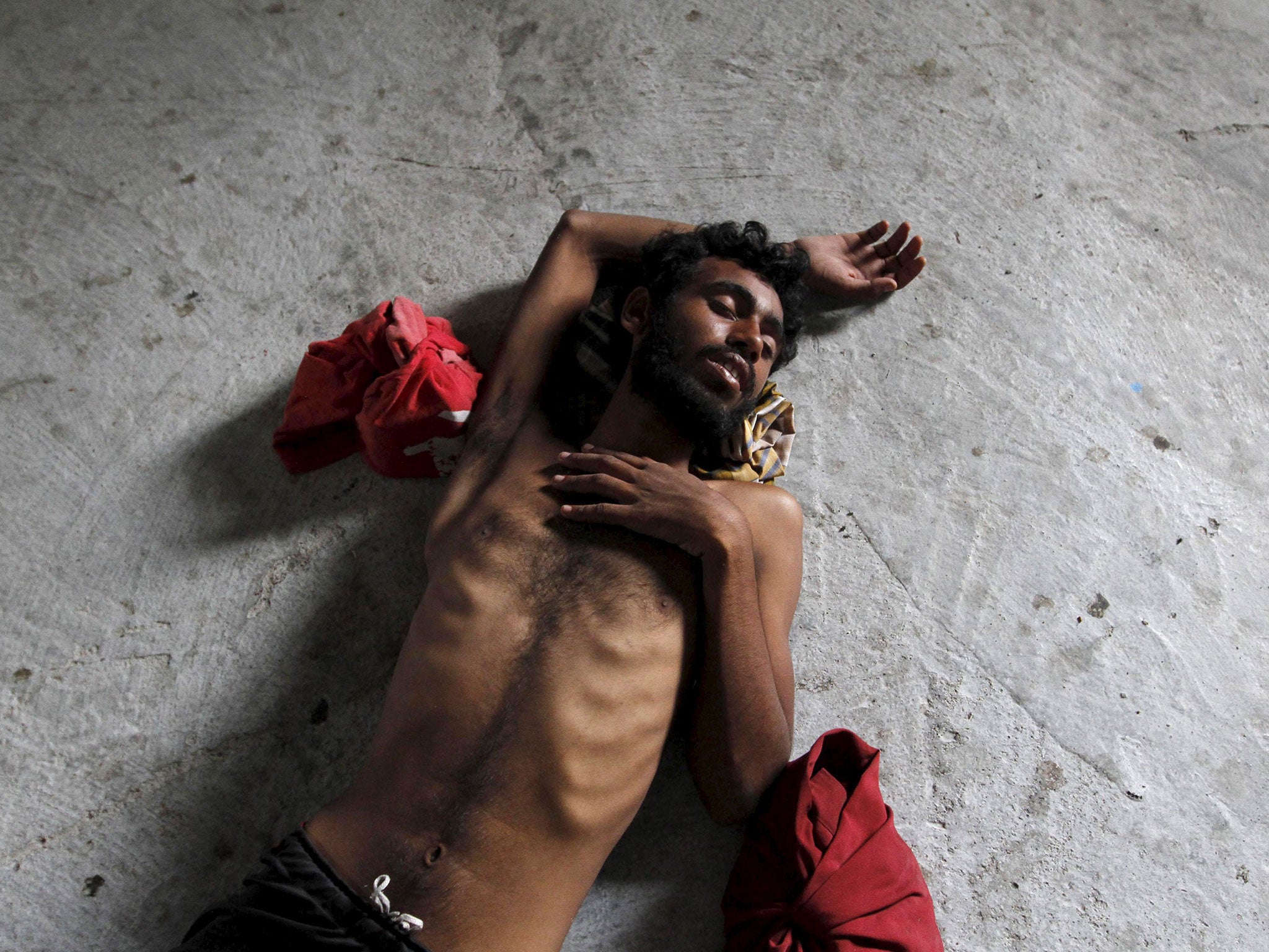 A migrant who travelled to Indonesia by boat sleeps in a shelter