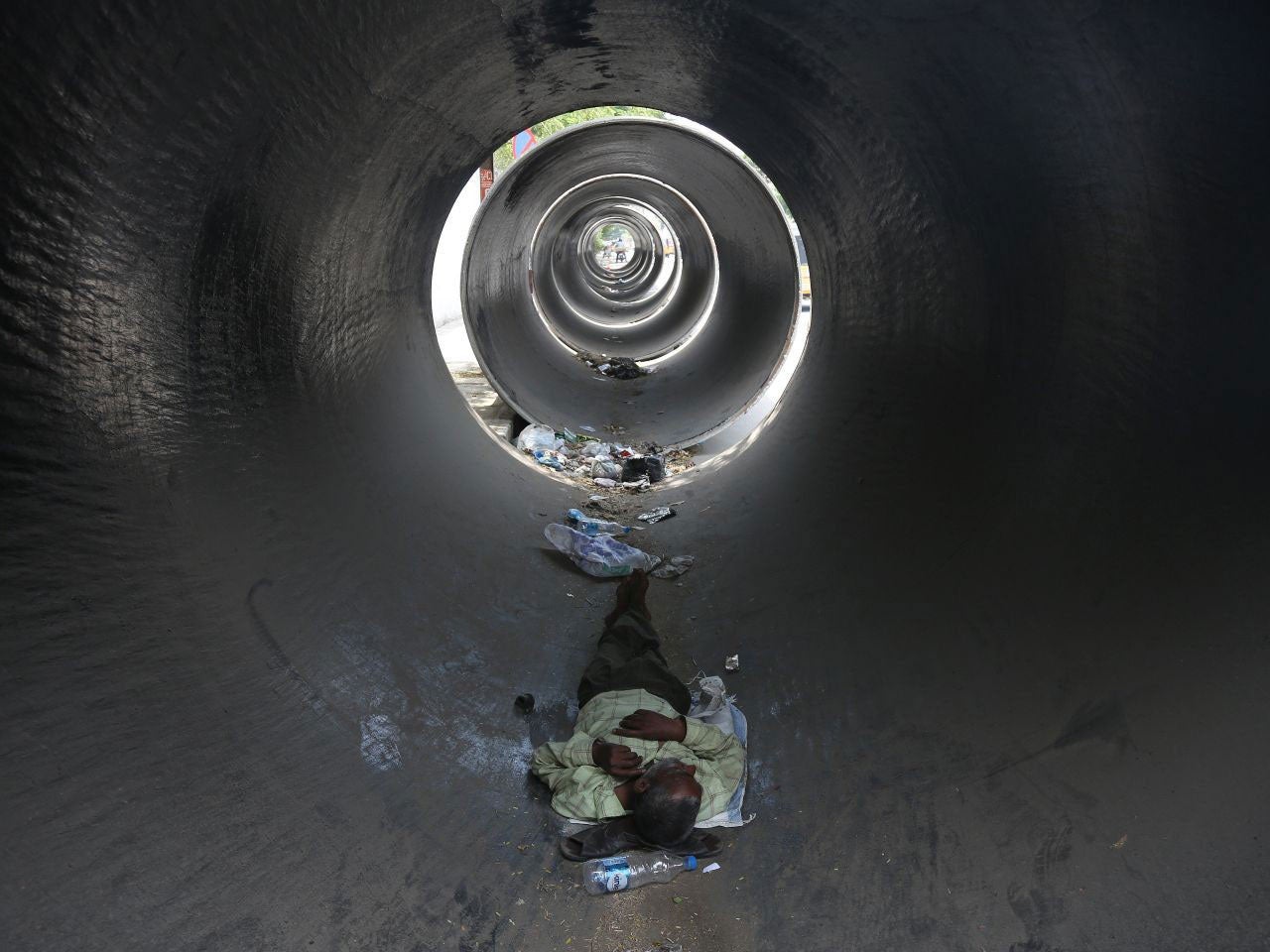 A man sleeping in a concrete pipe to escape the burning son in Hyderabad