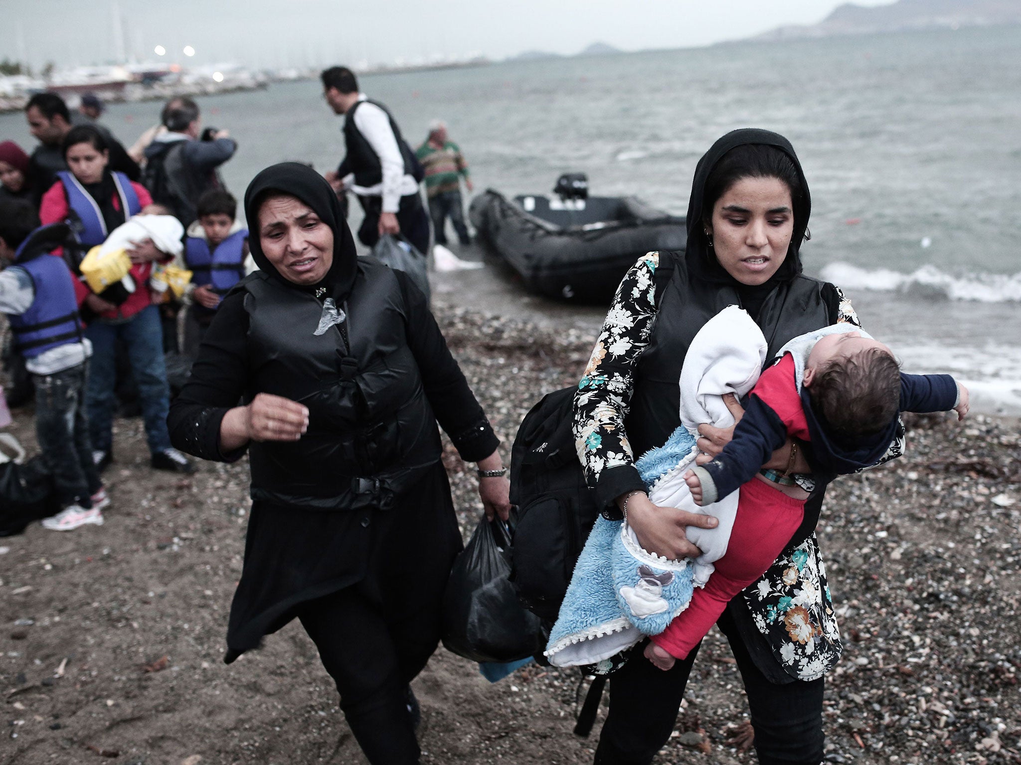 Afghan migrant women arrive on a beach