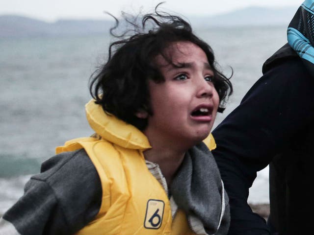 A Afghan migrant girl and a woman arrive on a beach on the Greek island of Kos in a rib boat