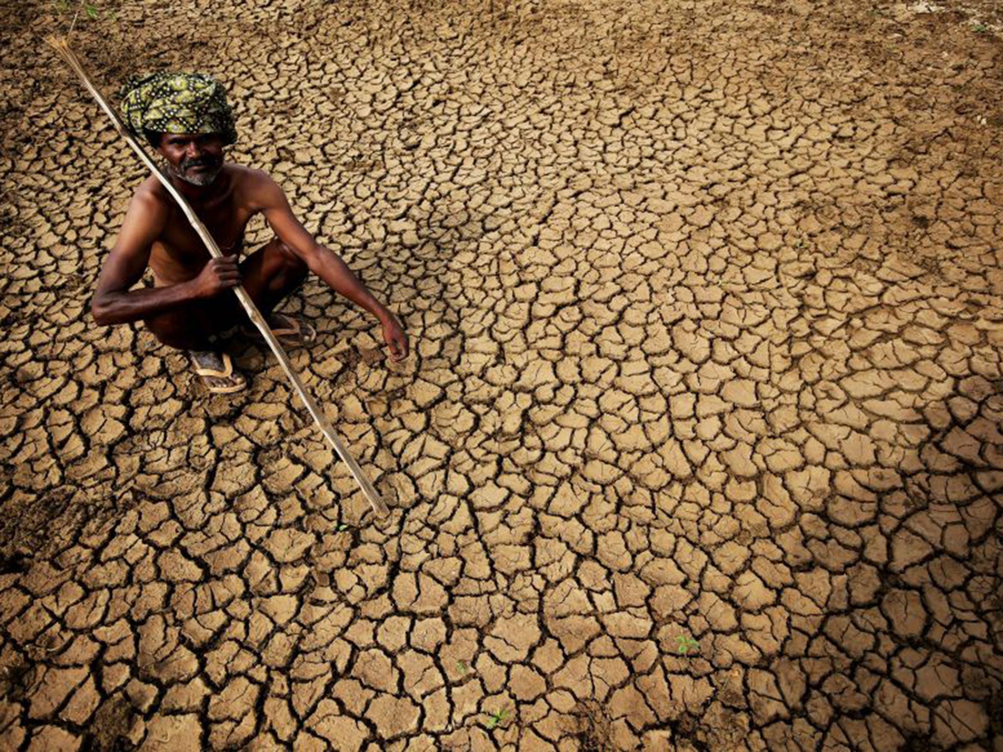 A farmer sits on his dried up land in Gauribidanur in Karnataka