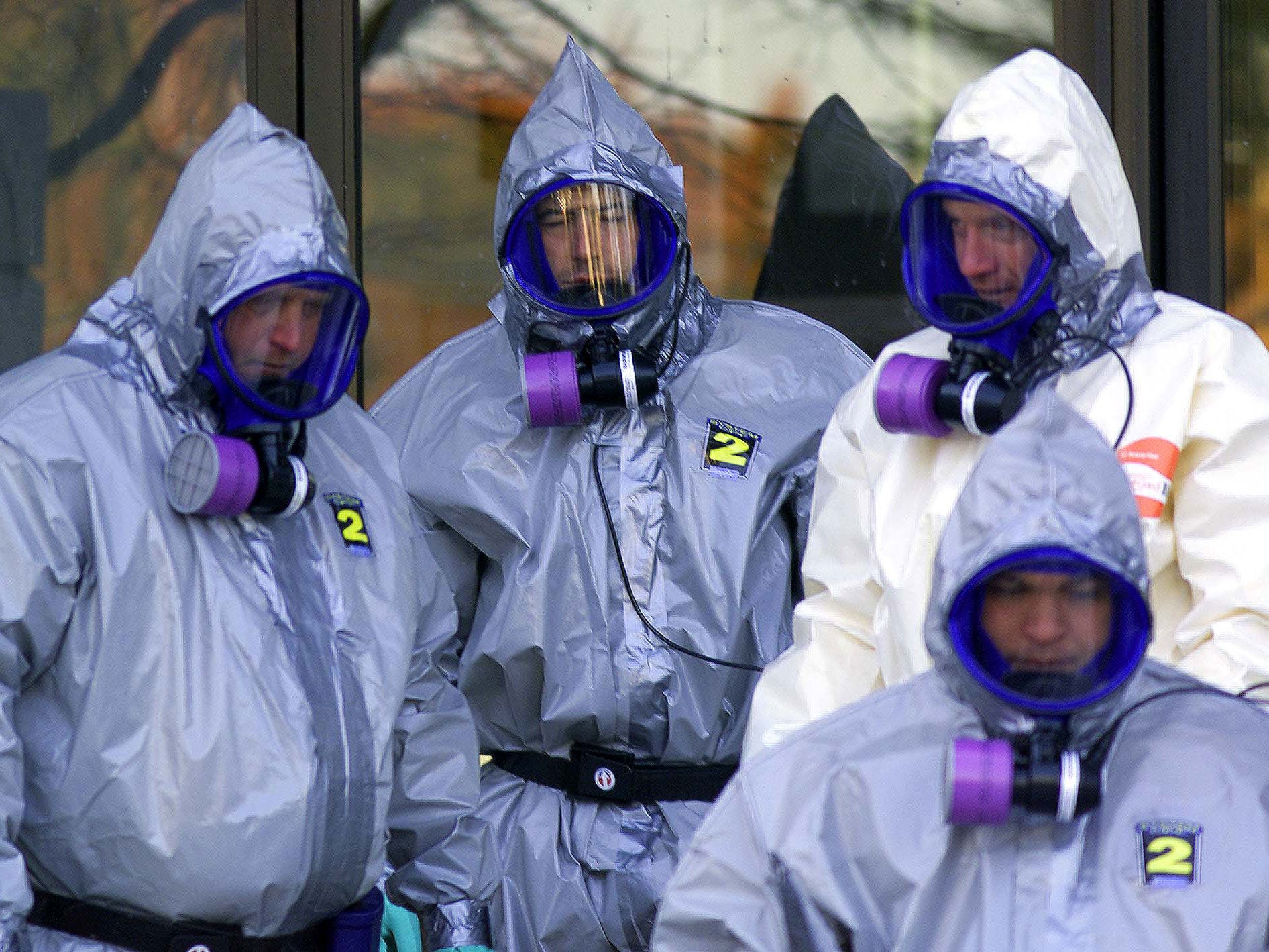 US Coast Guard hazardous material workers in protective suits and breathing systems stand together before entering the sealed US Senate hart building as contamination tests continue searching for anthrax spores inside the US Capitol building in Washington,DC (credit: Paul J. Richards/ Getty)