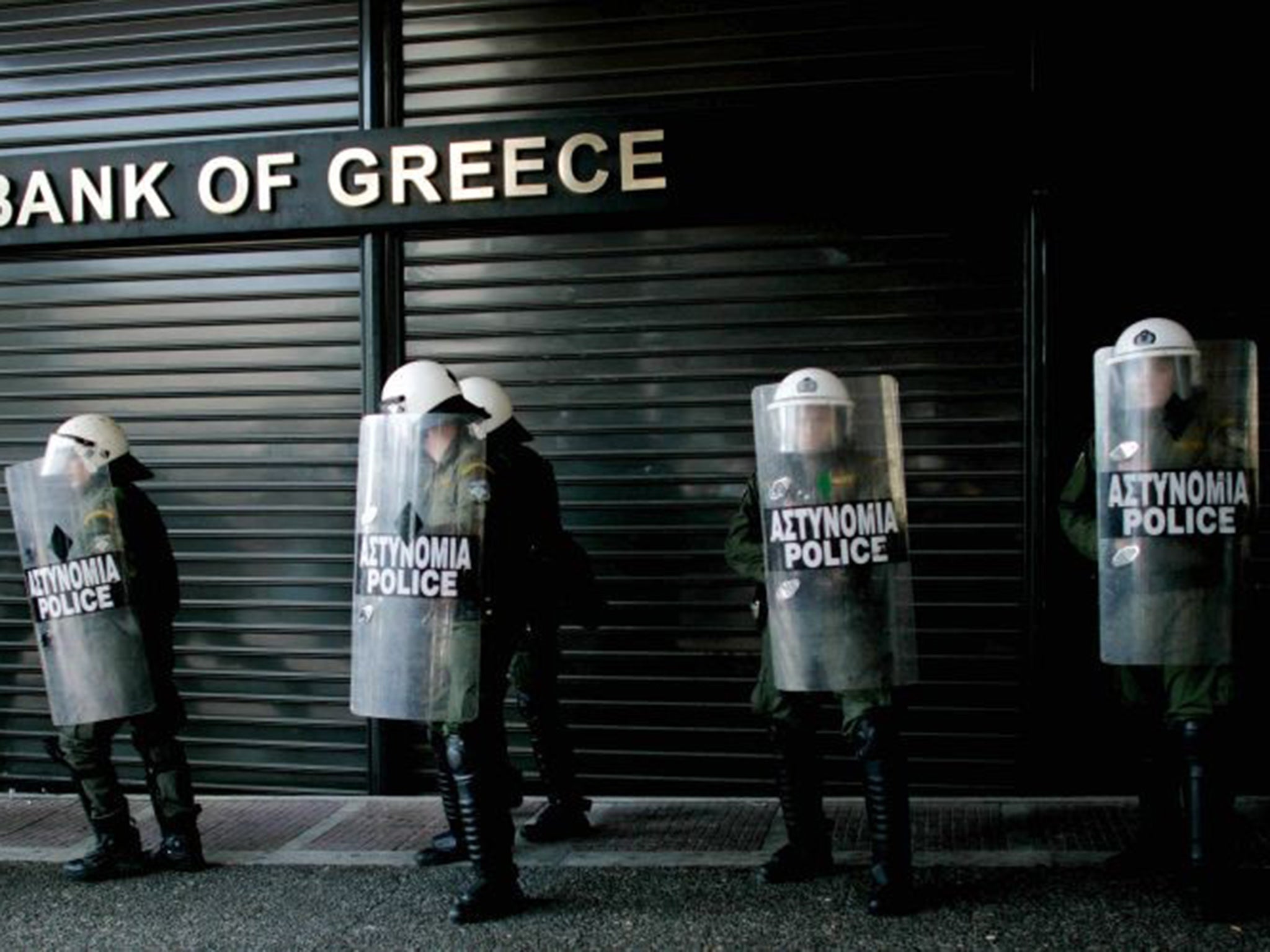 Riot police line up outside a closed branch of the National Bank of Greece during a 24-hour general strike in 2010 in Athens, Greece.
