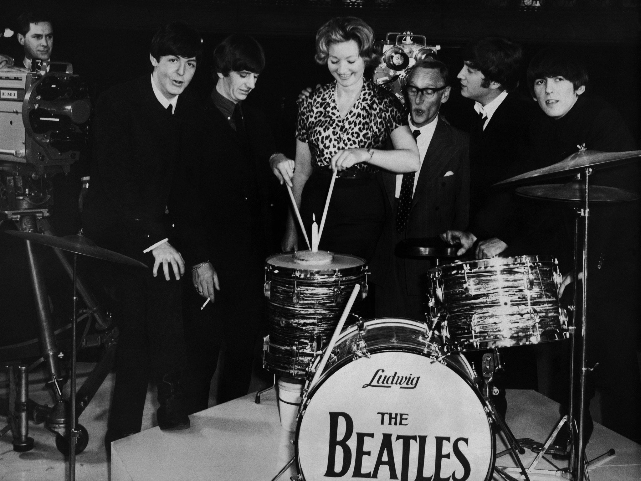 Fashion designer Julie Harris is presented with a birthday cake by The Beatles and Wilfred Brambell while working on A Hard Days Night